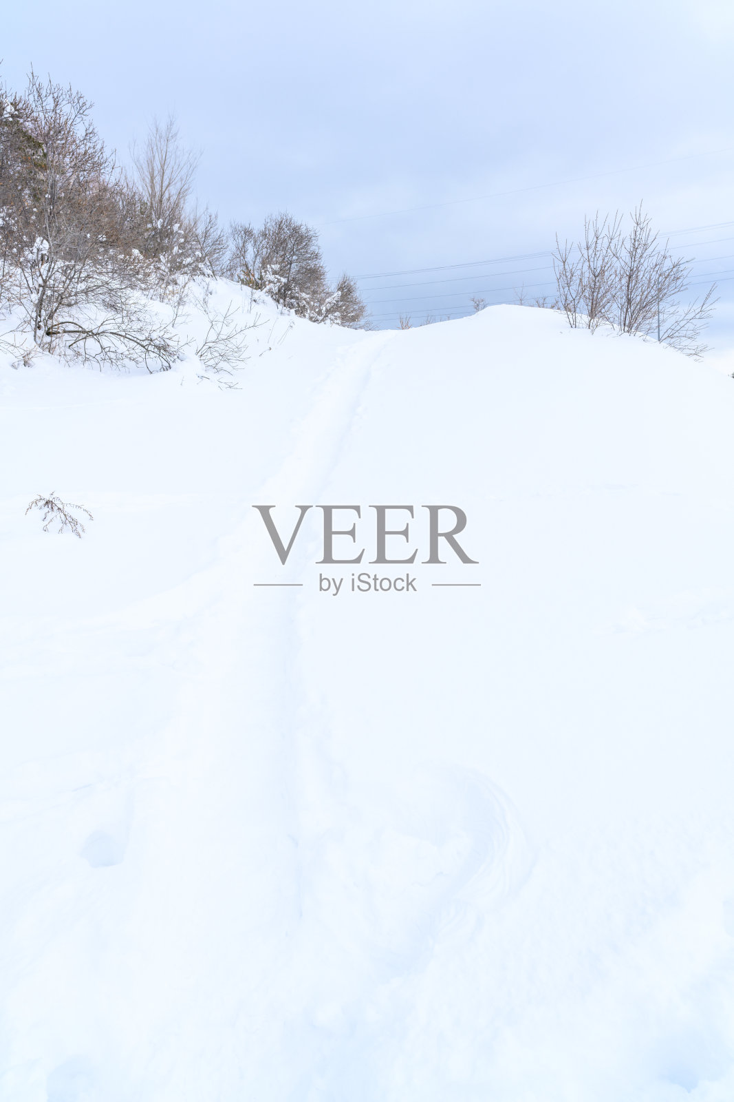 在积雪覆盖的徒步小径，美丽的冬季景观。照片摄影图片