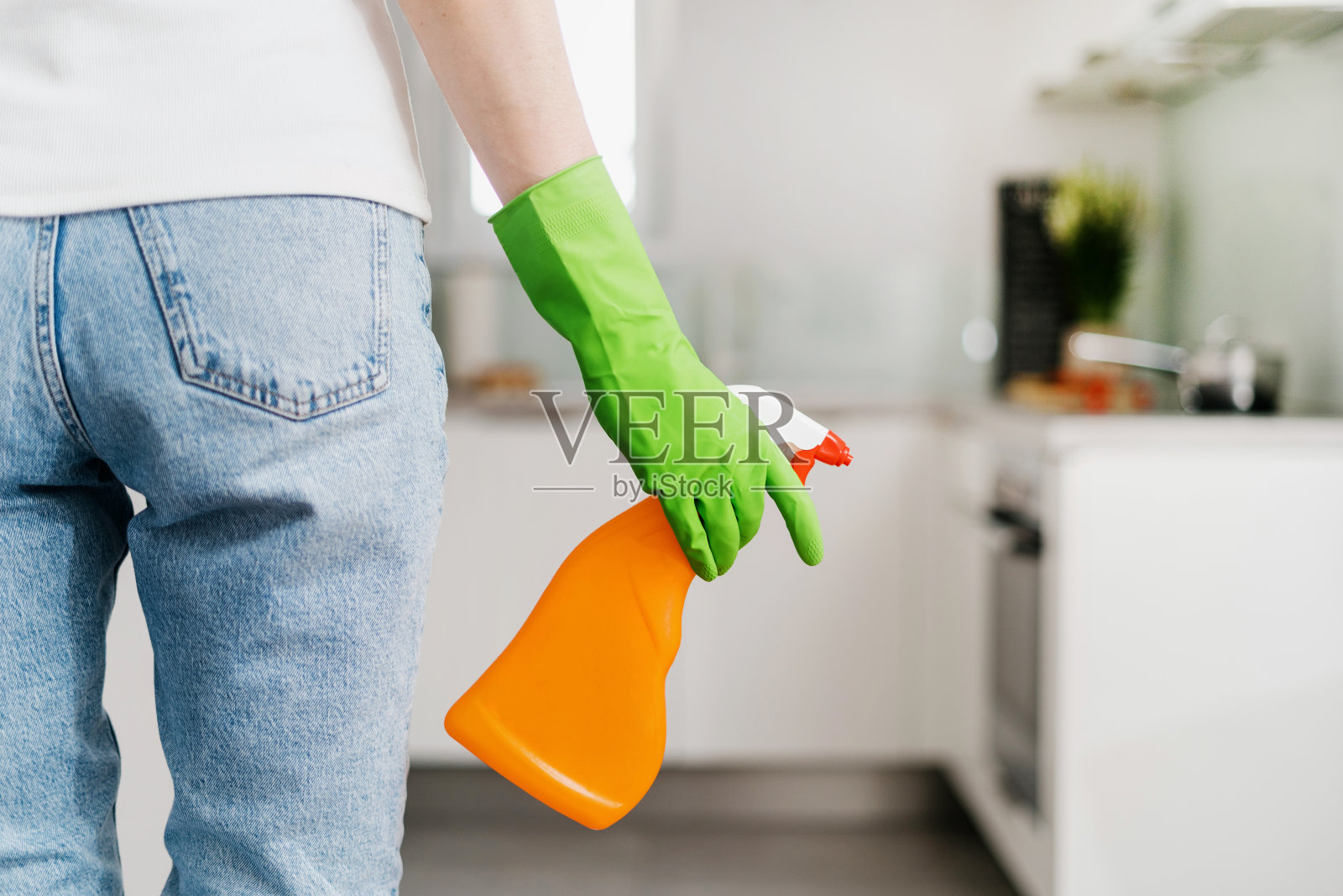 妇女拿着一瓶清洁剂在室内清洁，裁剪照片照片摄影图片