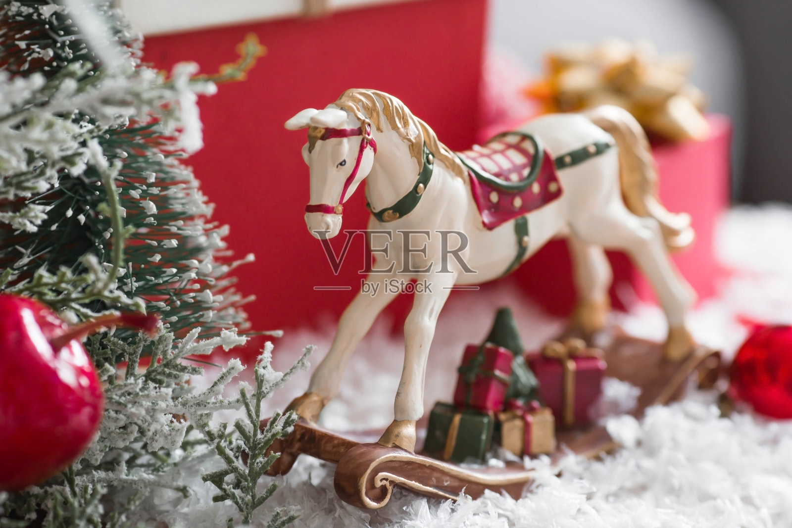 2023年新年快乐。一张圣诞卡，一个有摇摆马的横幅，圣诞树，礼物和背景中的一个美丽的散景。寒假在家的概念，温暖和舒适。照片摄影图片