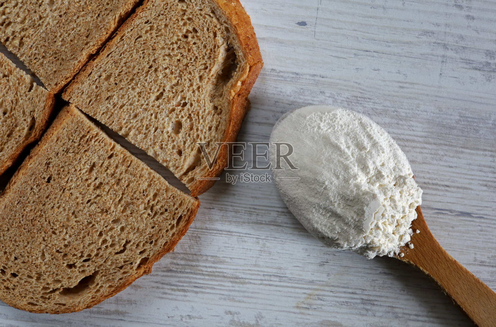 用木勺盛面粉，搭配有机切片面包照片摄影图片