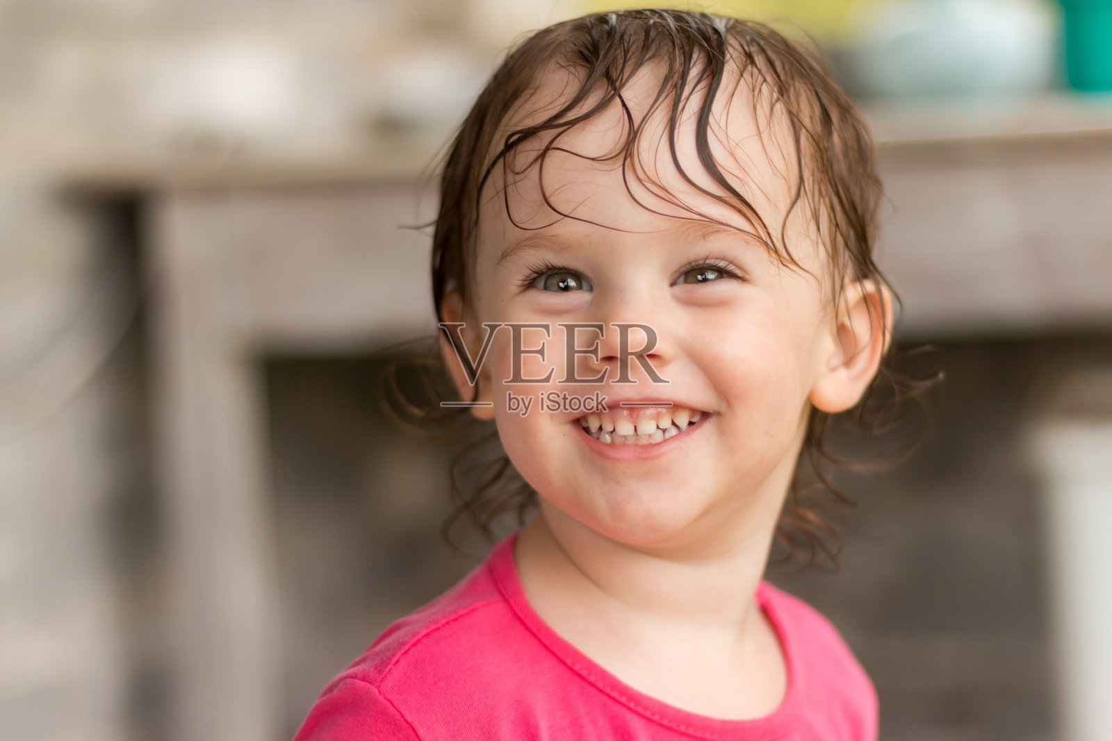 闪亮的微笑孩子湿头发模糊的夏天背景。小女孩在公园外面玩得很开心照片摄影图片