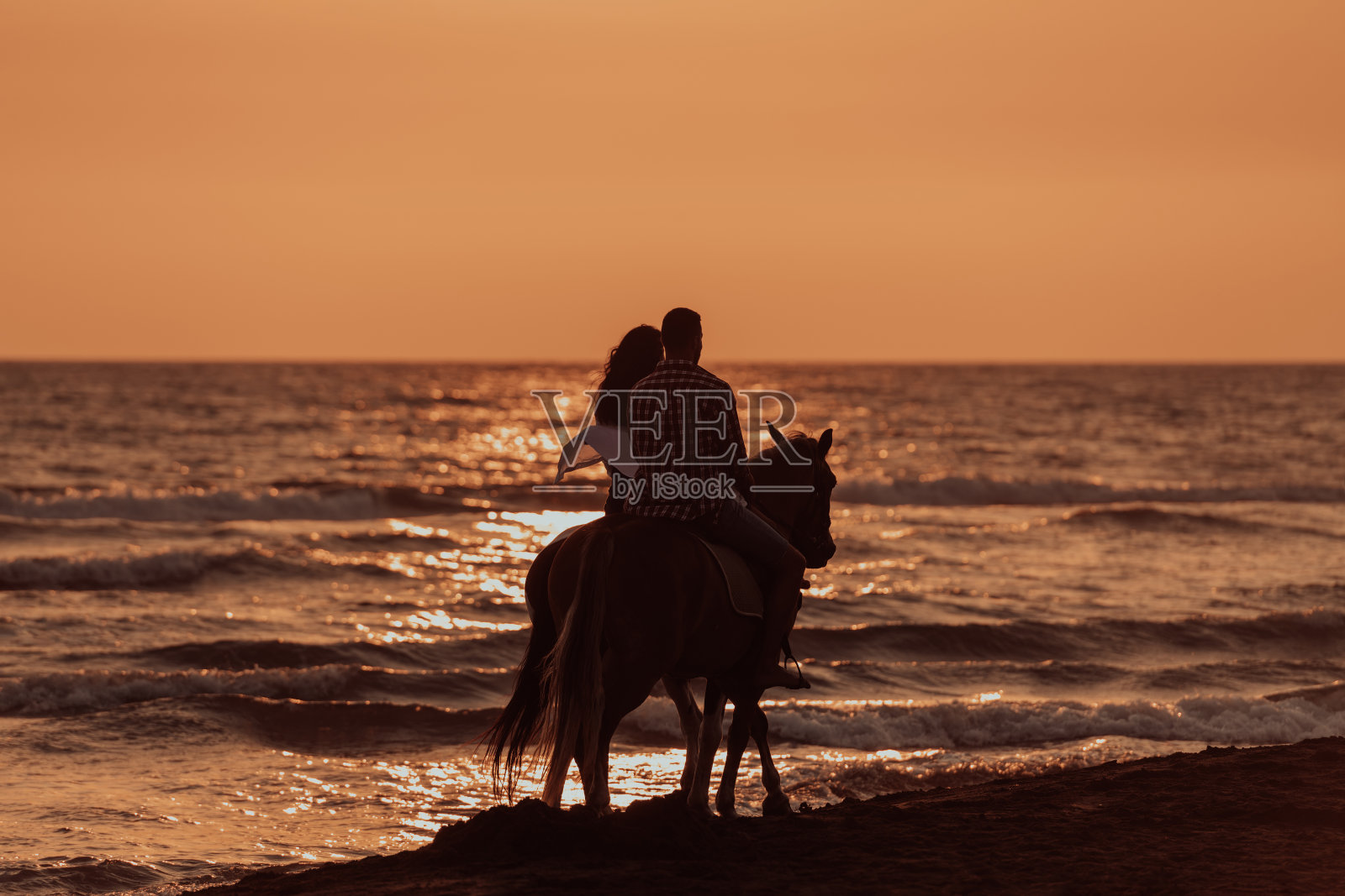 一家人和孩子们一起在沙滩上骑马。有选择性的重点照片摄影图片