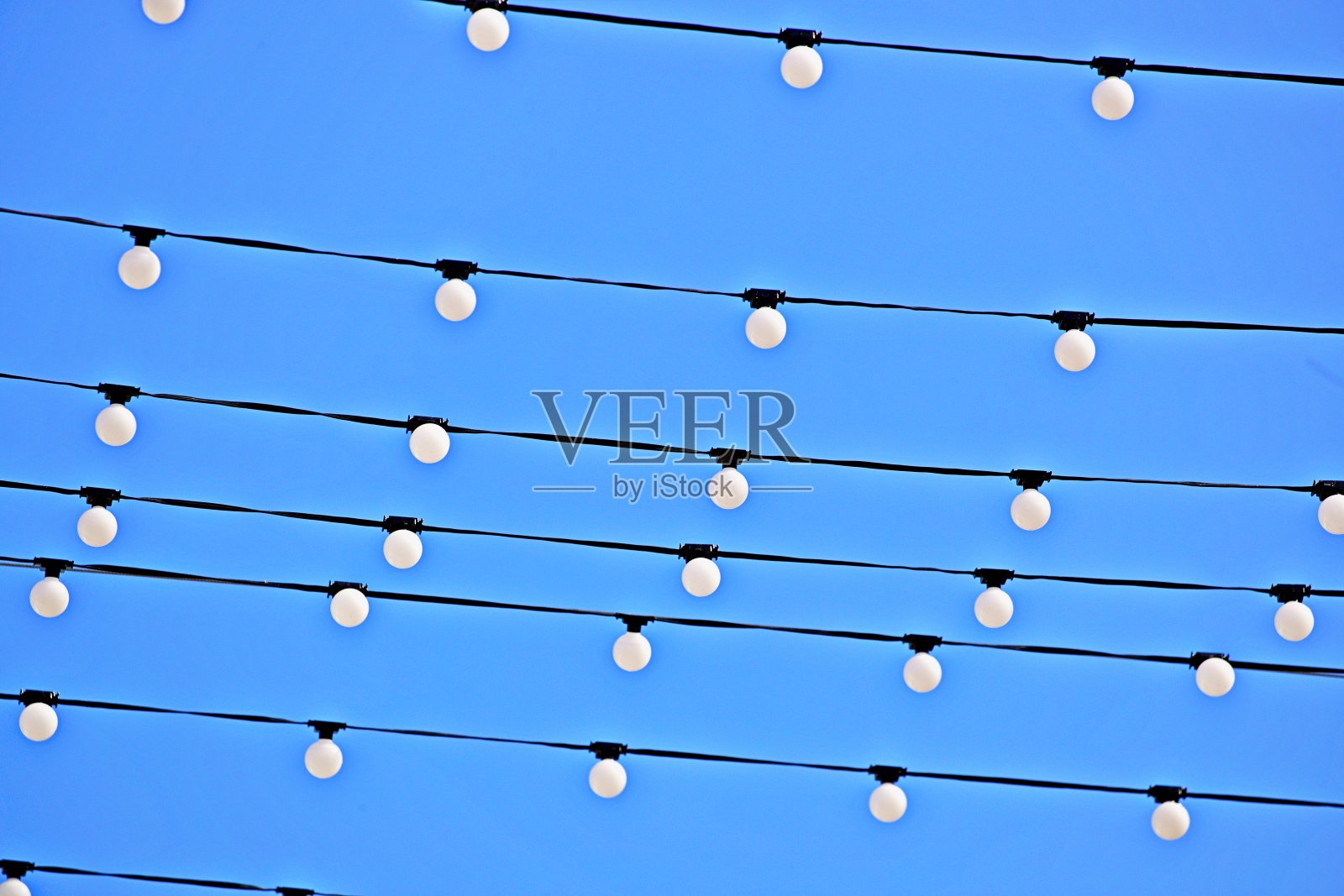 灯泡挂在空中的电缆上照片摄影图片
