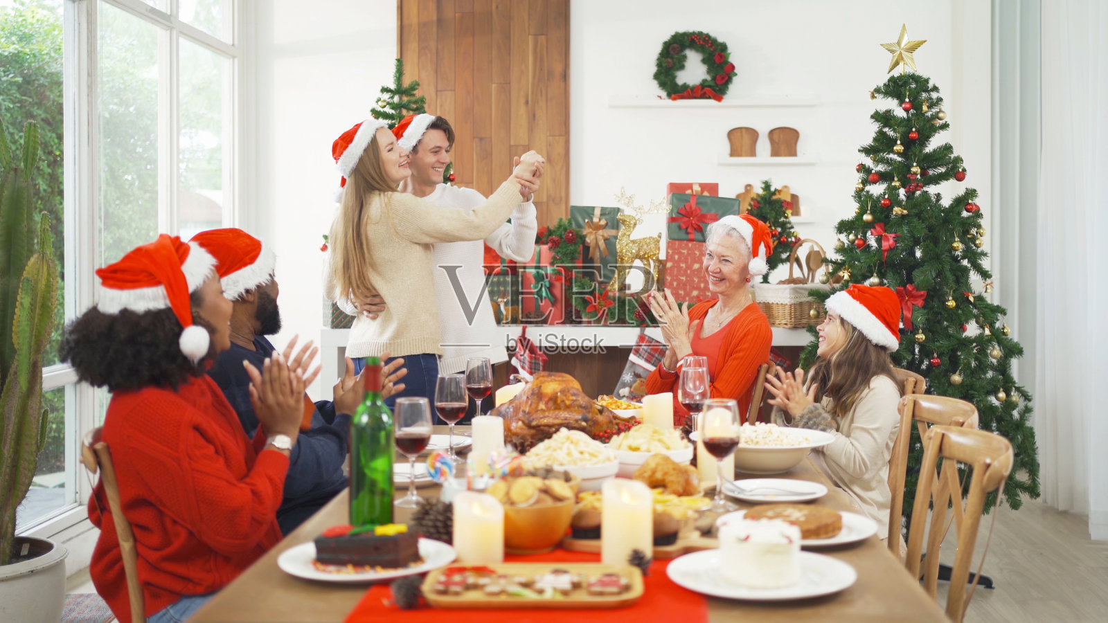 多民族人民一起跳舞的画像。他们有一个庆祝聚会在圣诞快乐夜，圣诞节在假日在家里或家里。人们的生活方式。感恩节。照片摄影图片