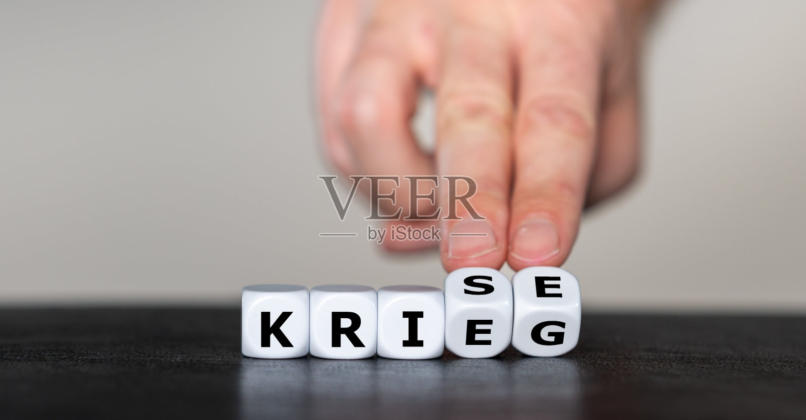 骰子组成德语单词“Krieg”(战争)和“Krise”(危机)。照片摄影图片