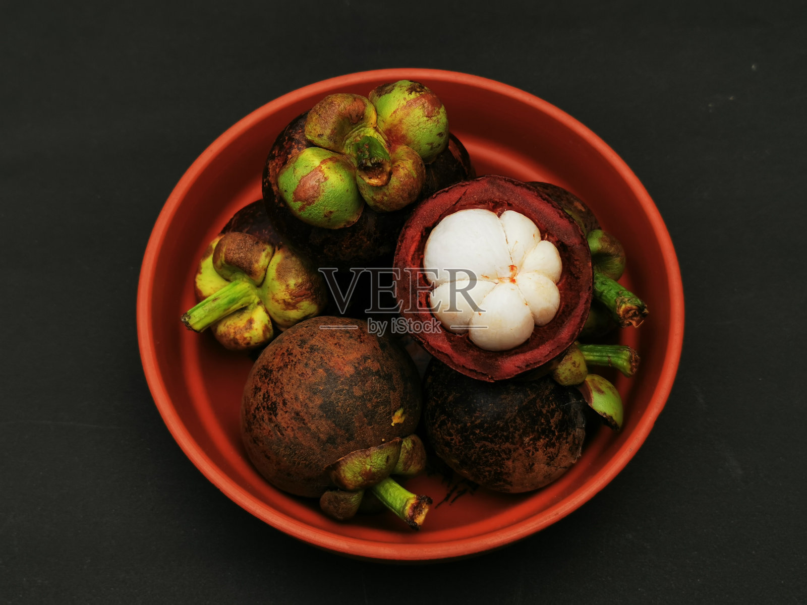 新鲜山竹果在黑色背景的碗照片摄影图片