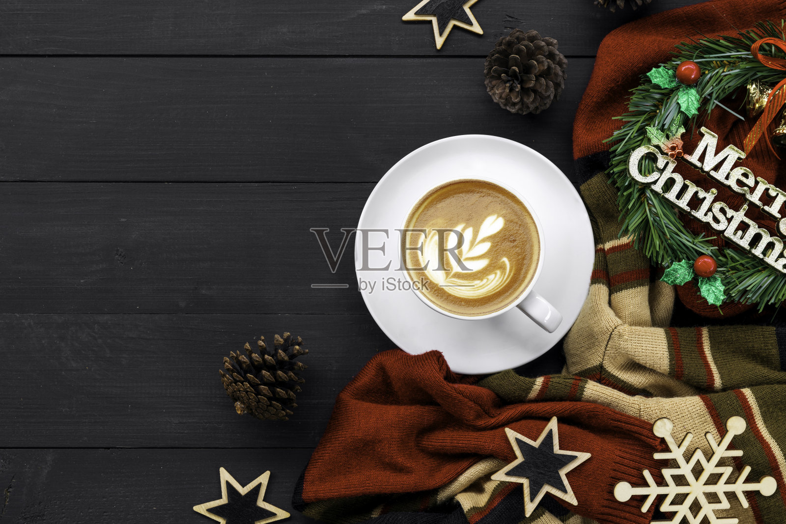 黑色木桌上放着圣诞装饰的咖啡。俯视图照片摄影图片