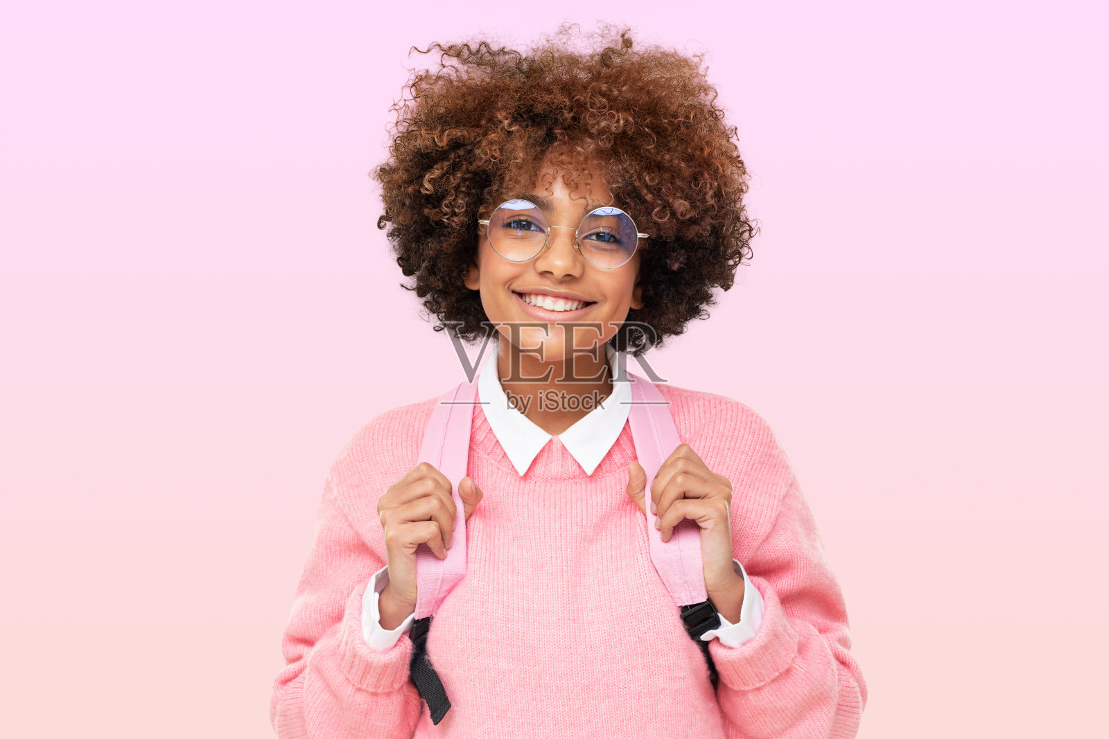 漂亮的非洲少女肖像，高中生卷曲的非洲发型和粉红色的背包照片摄影图片