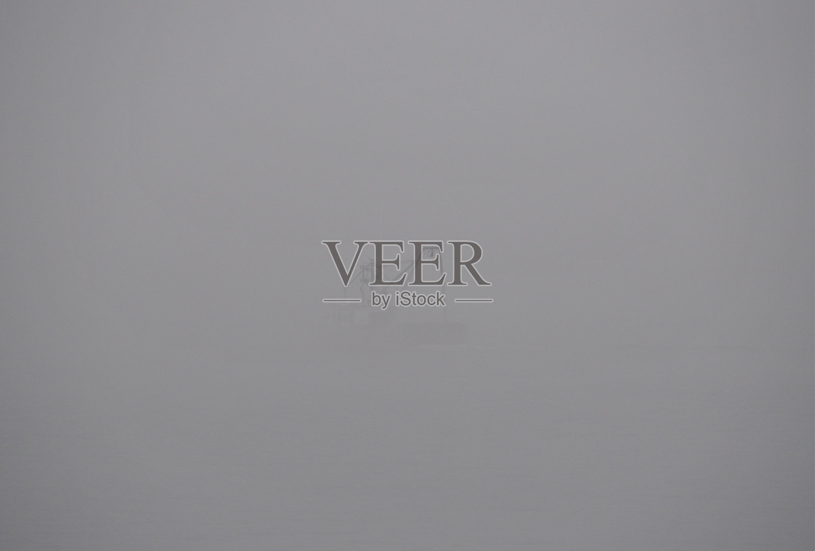 在加拿大新不伦瑞克的芬迪湾，一艘拖网渔船消失在雾中照片摄影图片