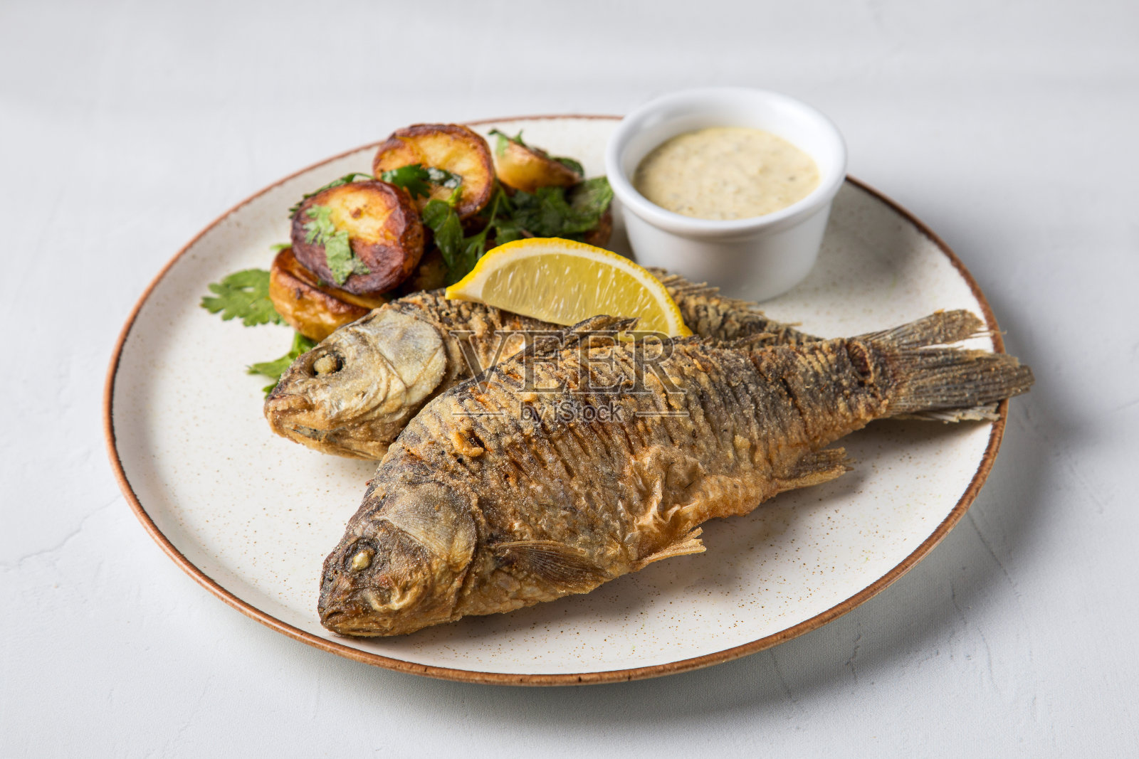 鱼作为食物，白色的盘子与炸鱼与土豆，一个白色的盘子准备作为食物照片摄影图片