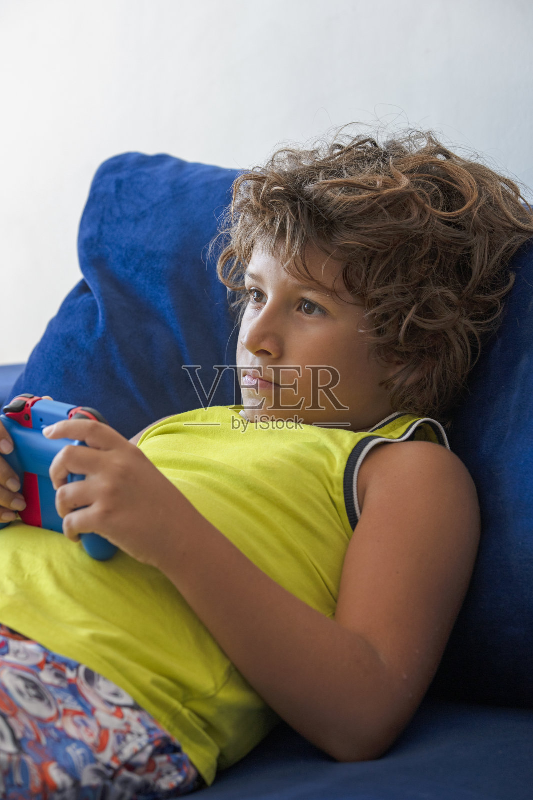 男孩拿着游戏手柄在玩游戏机游戏照片摄影图片