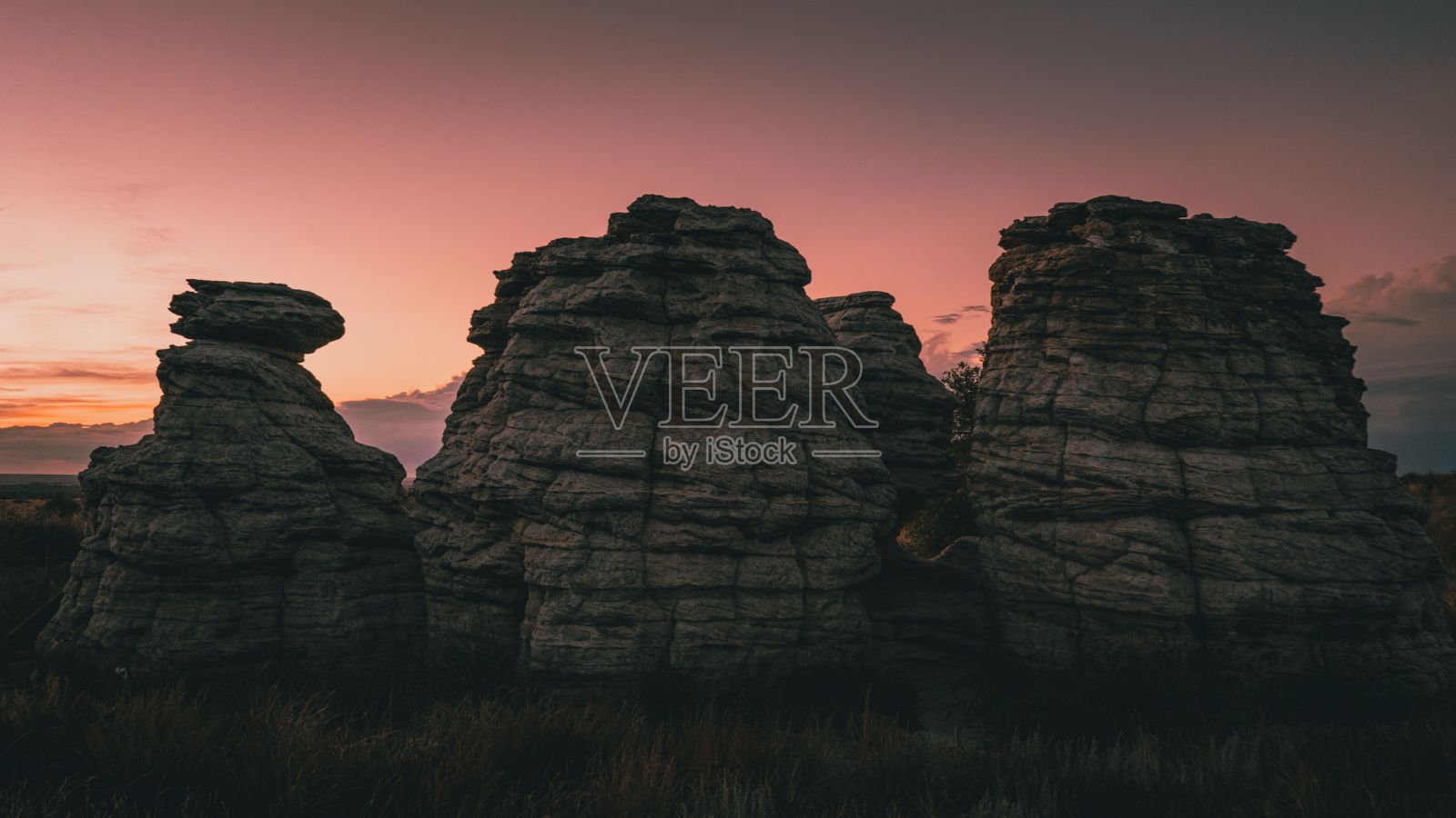 粉红色的落日背景下的岩层令人着迷照片摄影图片