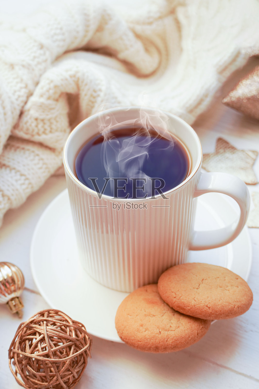 冬季、圣诞节、新年装饰构图、概念、背景。白色马克杯，一杯茶，咖啡，蒸汽，饼干，云杉树枝，针织格纹。圣诞节早上的情绪。圣诞贺卡。照片摄影图片