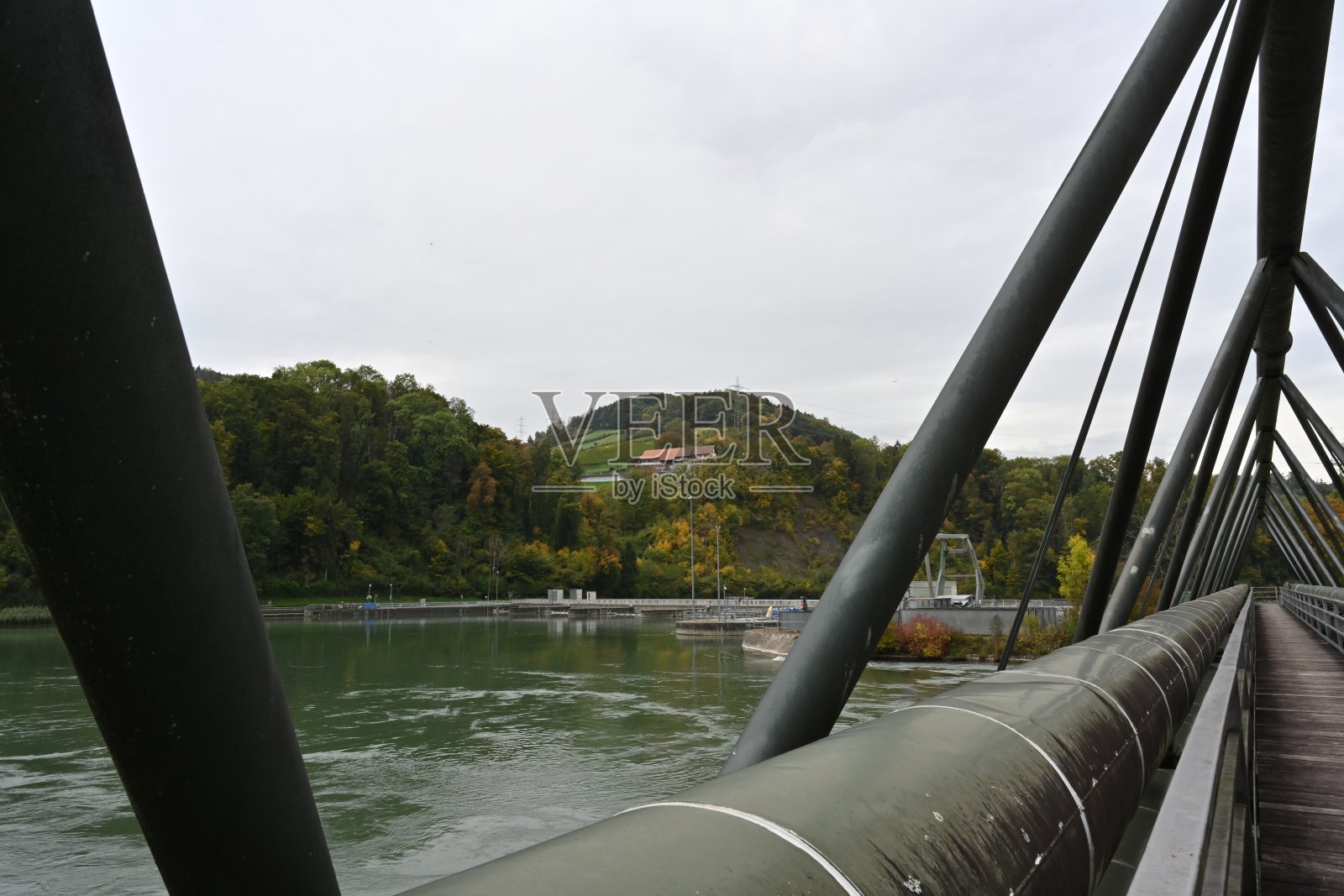 绿色油漆建筑和金属管道在横跨Aare河的桥的一侧减少透视。照片摄影图片