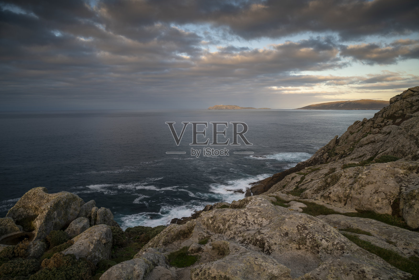 在加利西亚的马尔皮卡，夜晚多云的天空下，被悬崖包围的海洋景观照片摄影图片