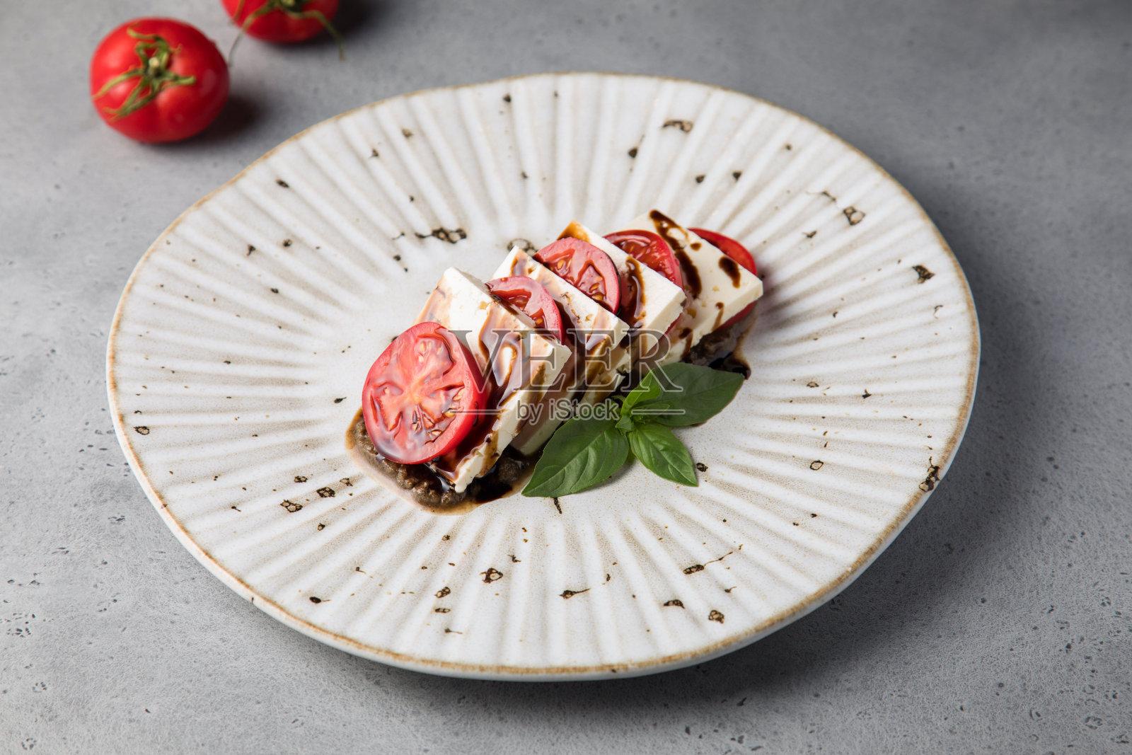 白色的盘子和蔬菜沙拉，灰色的背景是番茄，熟番茄，照片摄影图片