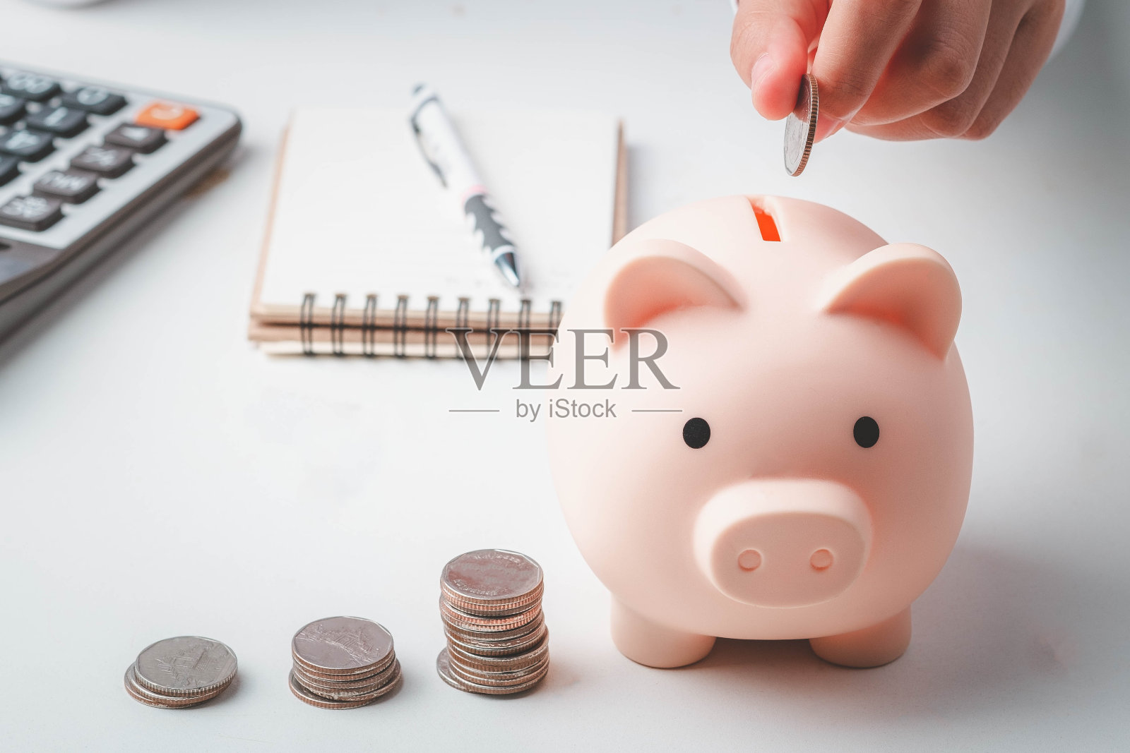 企业财务储蓄投资理念。手里拿着硬币，放进储蓄罐，数着他的钱。照片摄影图片