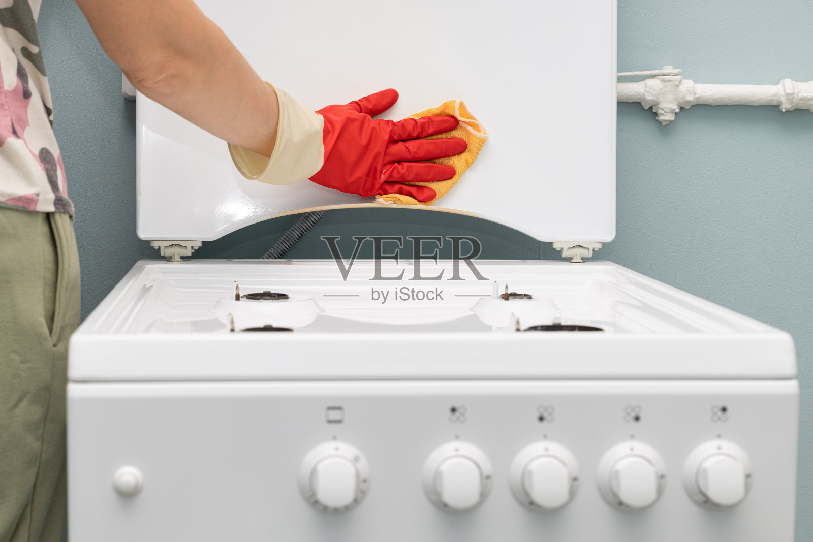 有人用抹布洗煤气炉。照片摄影图片