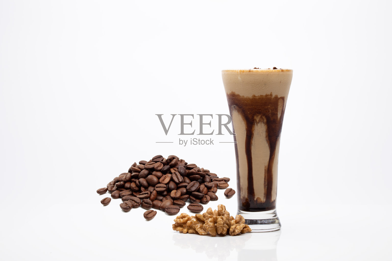 在白色背景上用胡桃木拍摄的咖啡奶昔特写照片摄影图片