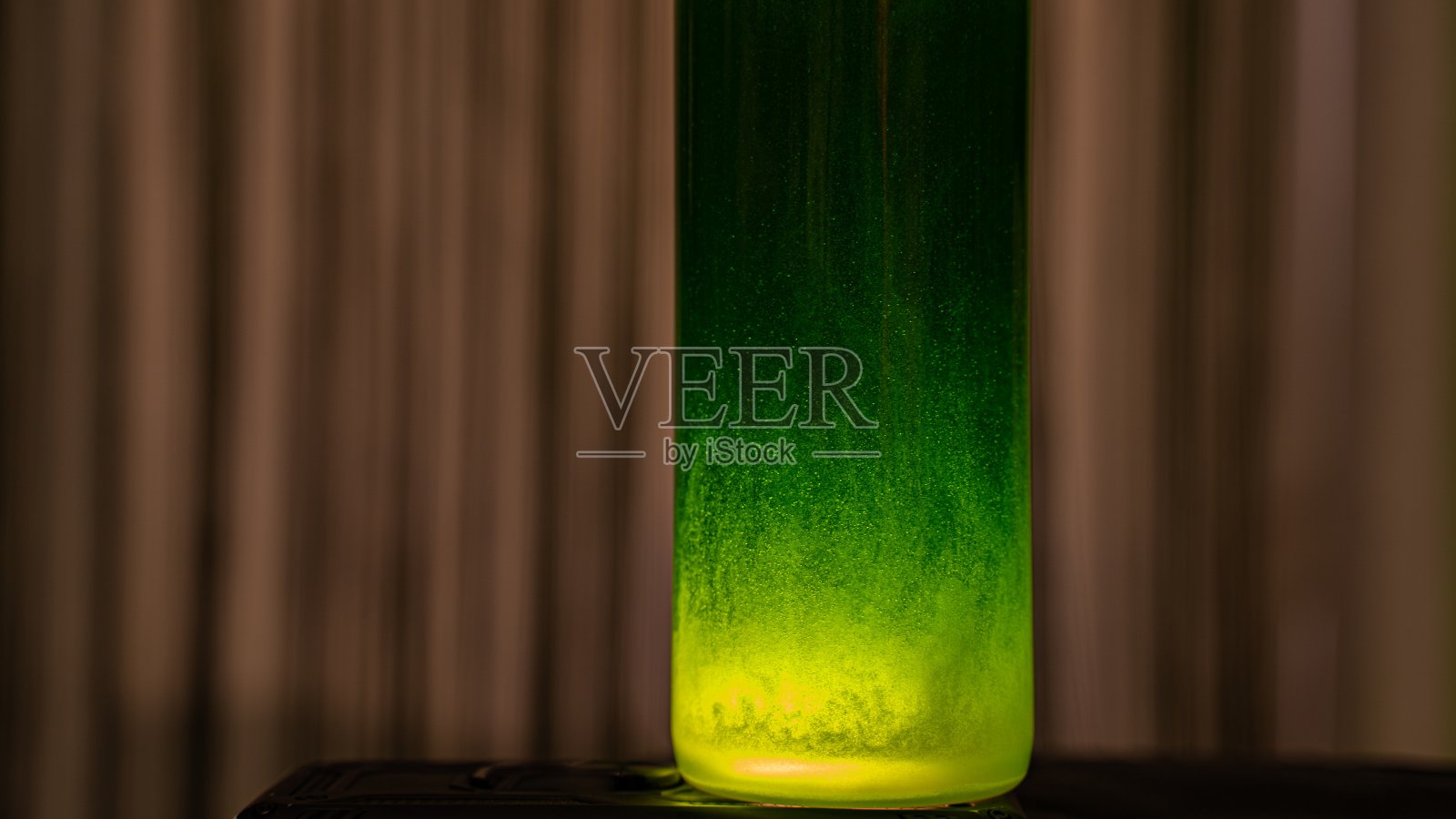 用黄色光照亮的绿色液体玻璃照片摄影图片