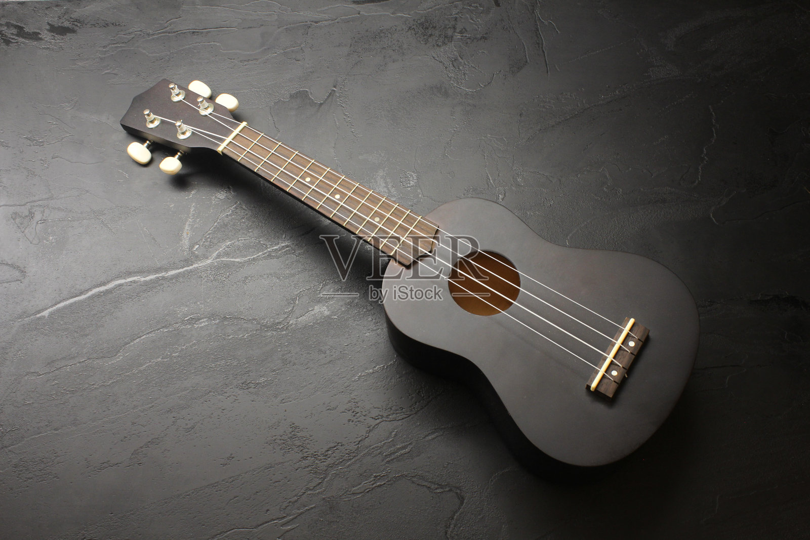 黑色尤克里里在黑色表面上的高角度镜头照片摄影图片