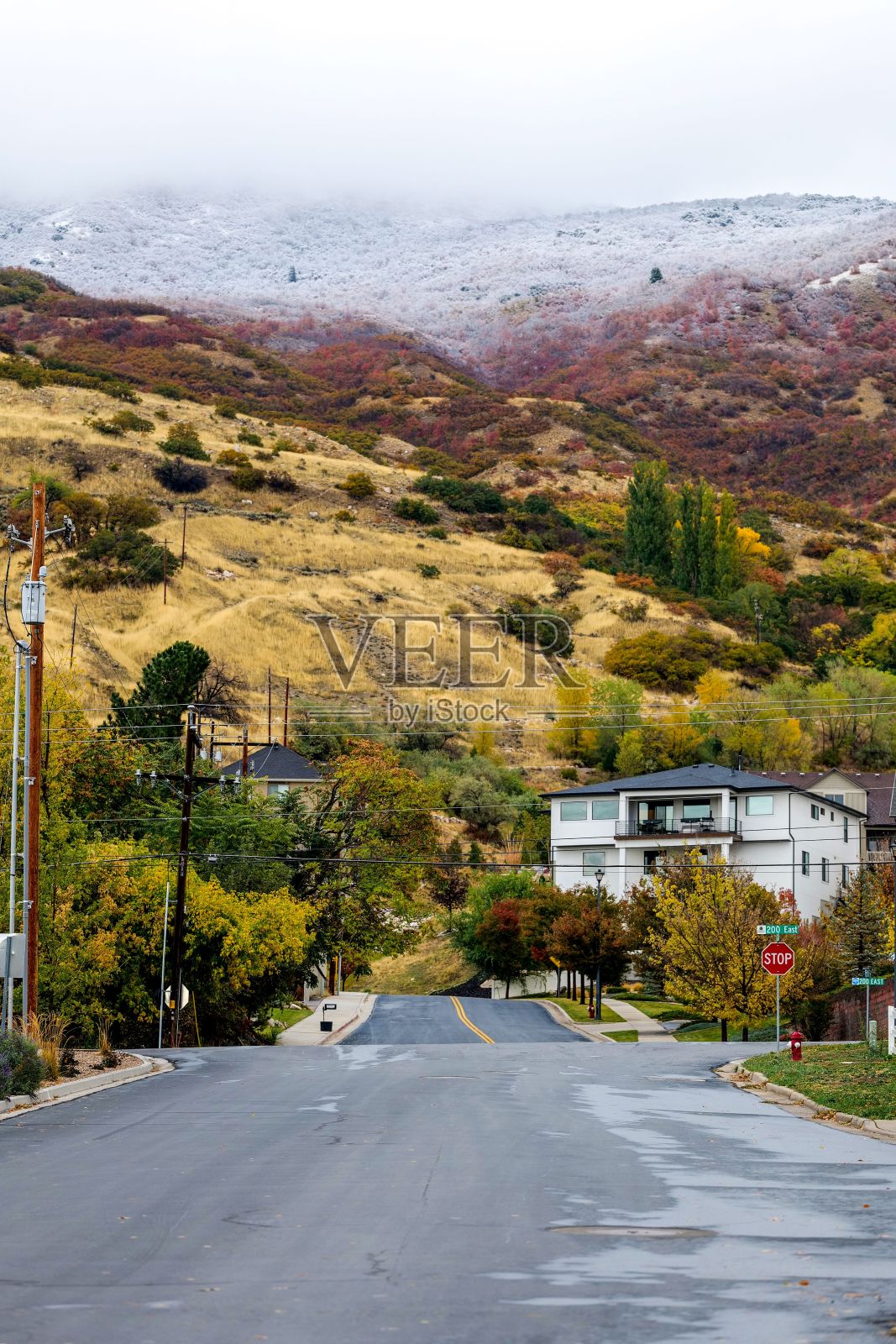 垂直拍摄的邻里街道与山脉覆盖在雪的背景在犹他州，美国照片摄影图片