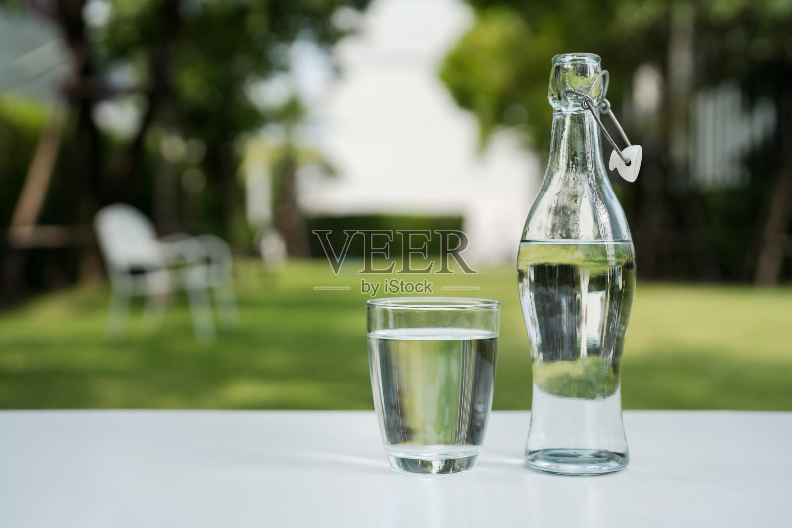 一杯干净的饮用水和一个水瓶。照片摄影图片