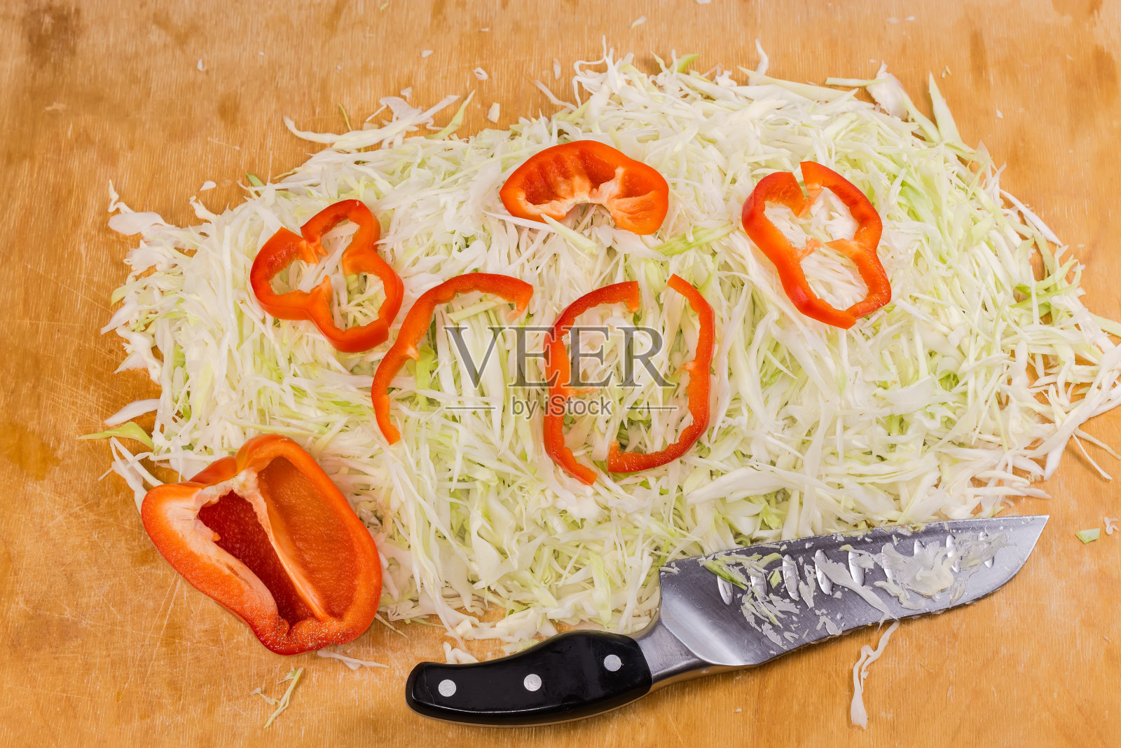 白卷心菜丝，甜椒丝，菜刀放在砧板上照片摄影图片