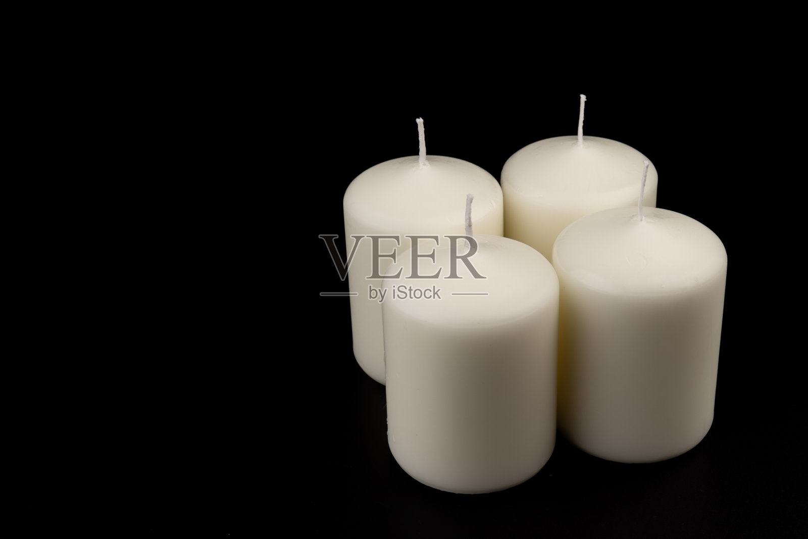 黑色背景上的白色蜡烛。特写,复制空间。照片摄影图片