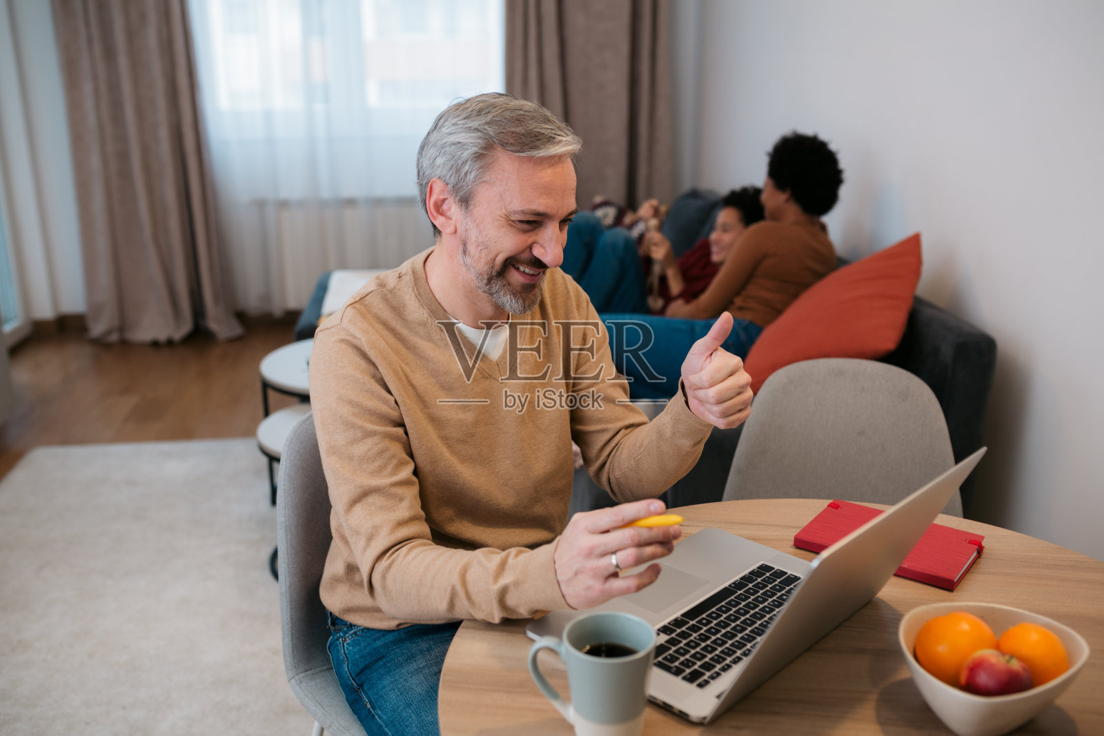 快乐的中年男人在家用笔记本电脑工作照片摄影图片