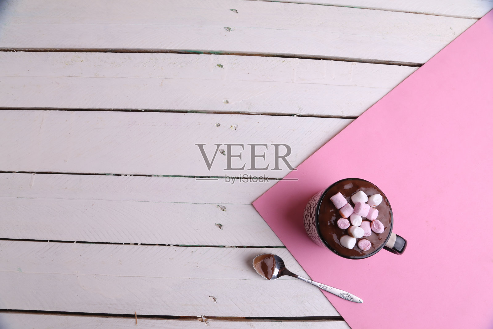 头顶上，厨房桌子上放着一大杯热巧克力，里面有棉花糖和勺子照片摄影图片