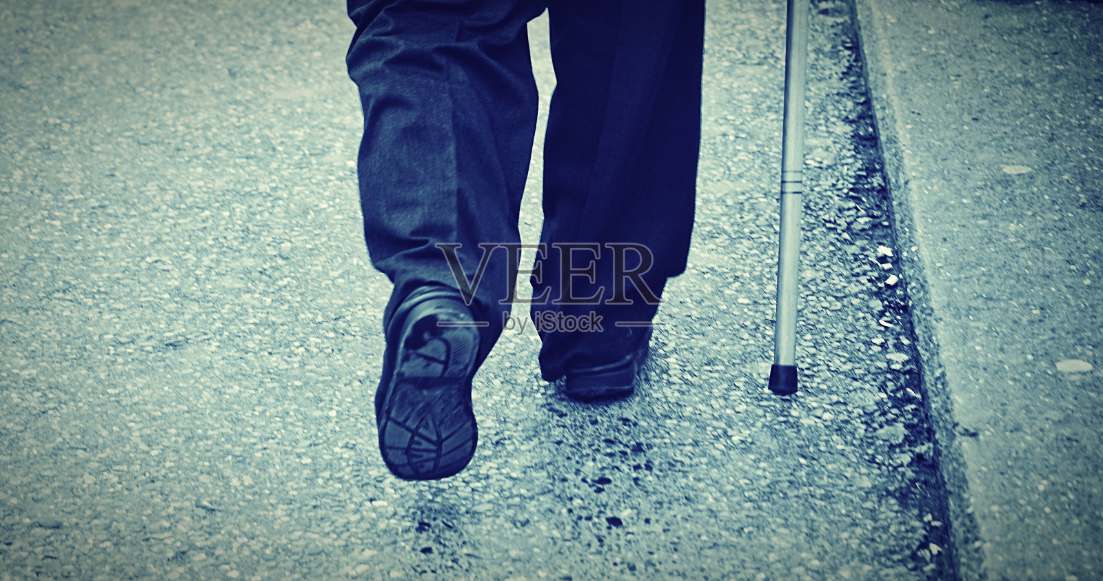 一个男人拄着拐杖走在街上照片摄影图片