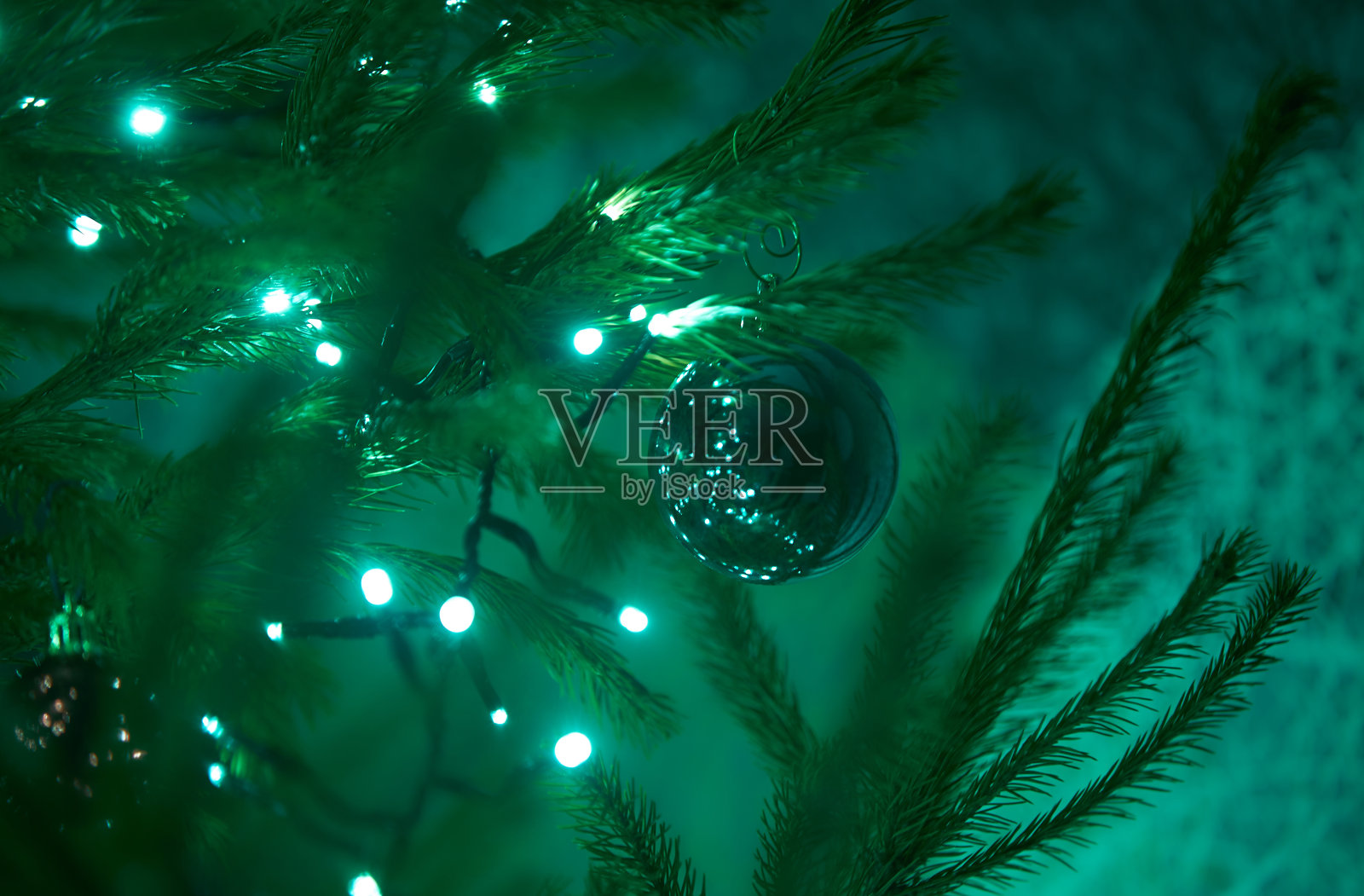 近距离的节日电蓝色花环在冷杉树枝与圣诞树装饰和糖果甜。挂在圣诞树树枝上的拐杖糖照片摄影图片