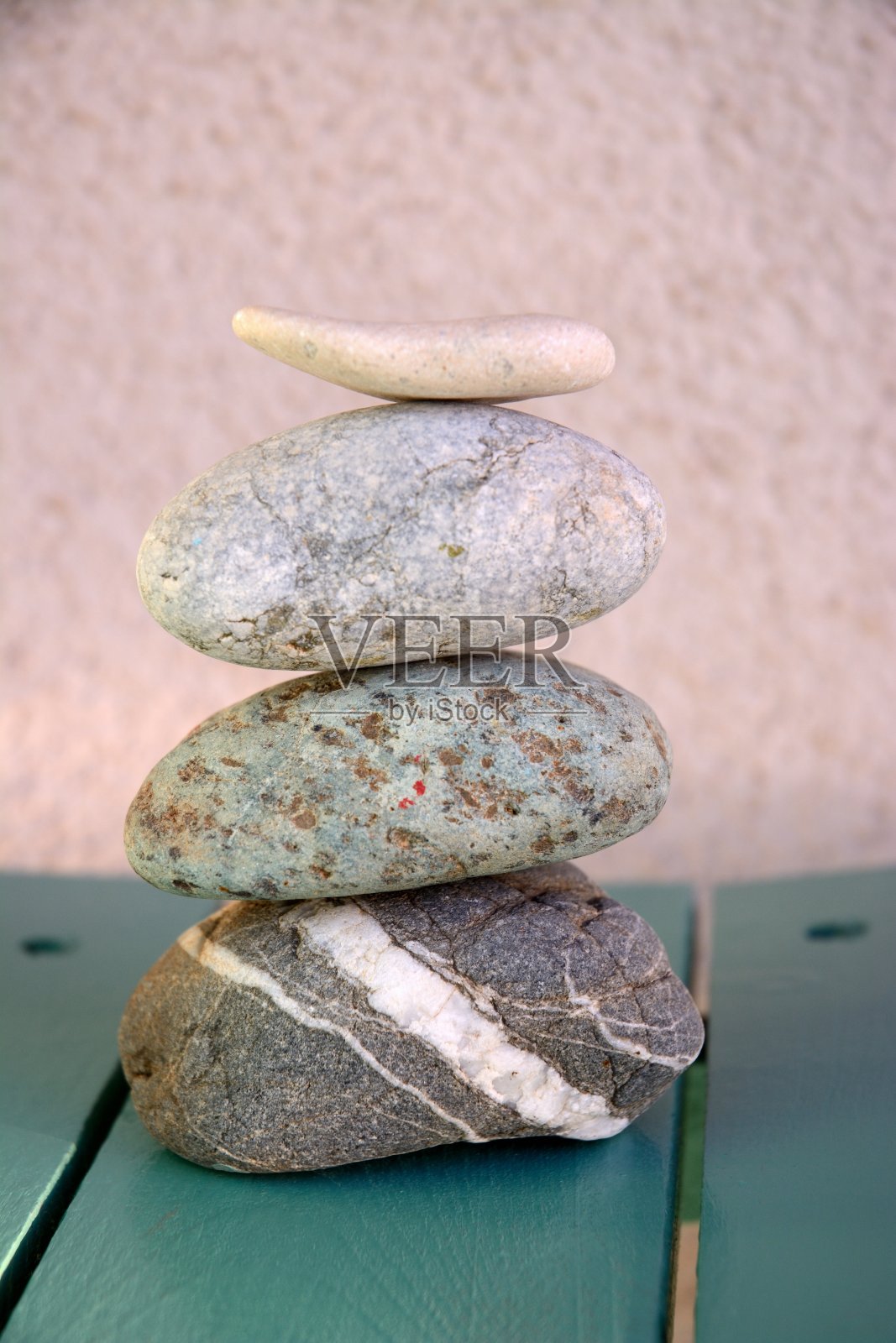垂直拍摄堆叠在木桌上的石头与模糊的背景-禅宗能量的概念照片摄影图片