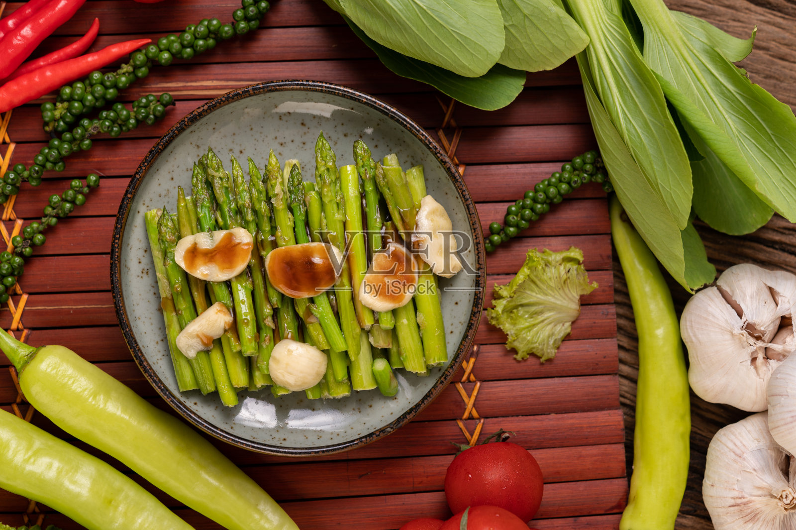 蚝油炒芦笋配甜椒盘新鲜的辣椒和番茄。照片摄影图片