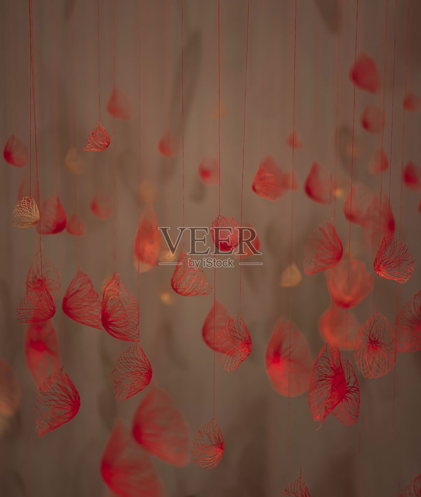 垂直视图的红色花卉饰品挂在灰色背景的前面照片摄影图片