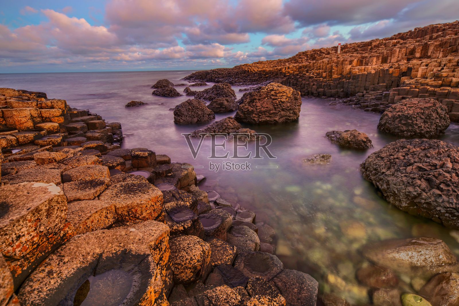 风景优美的海景与岩石在彩色日落天空背景在爱尔兰照片摄影图片