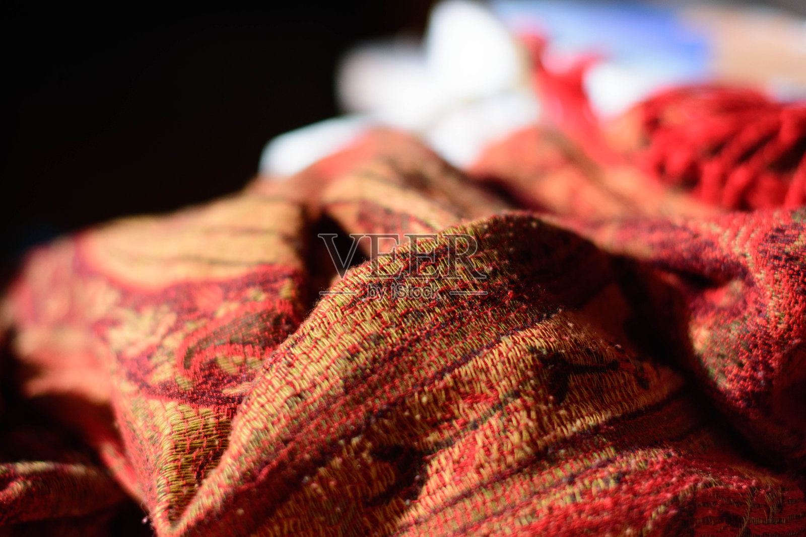 红色、橙色、金色和棕色的羊绒围巾放在桌子上照片摄影图片