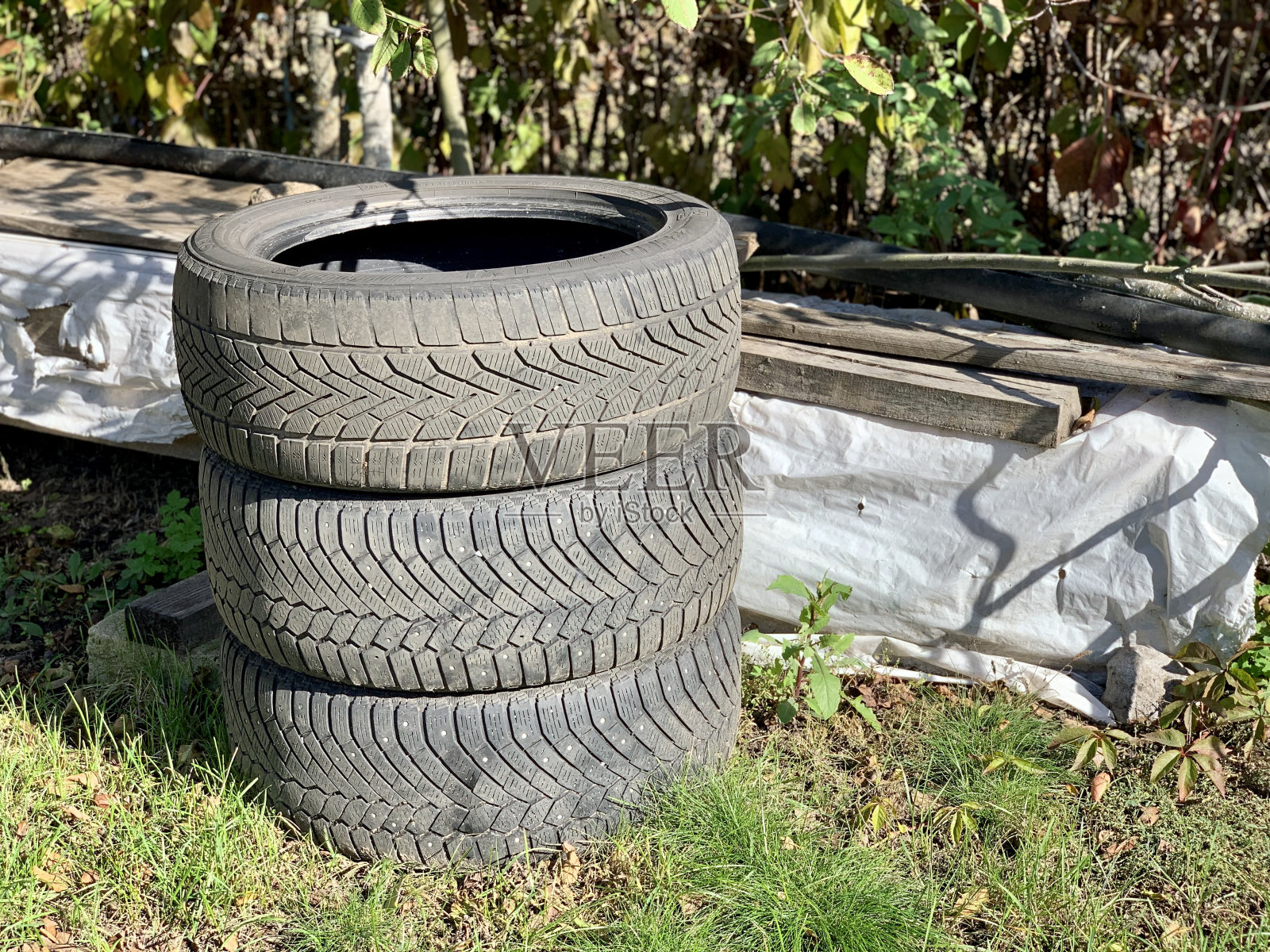 草地上一辆汽车的橡胶轮胎。生态和环境污染的问题，橡胶废料的处理从生产和汽车工业。照片摄影图片