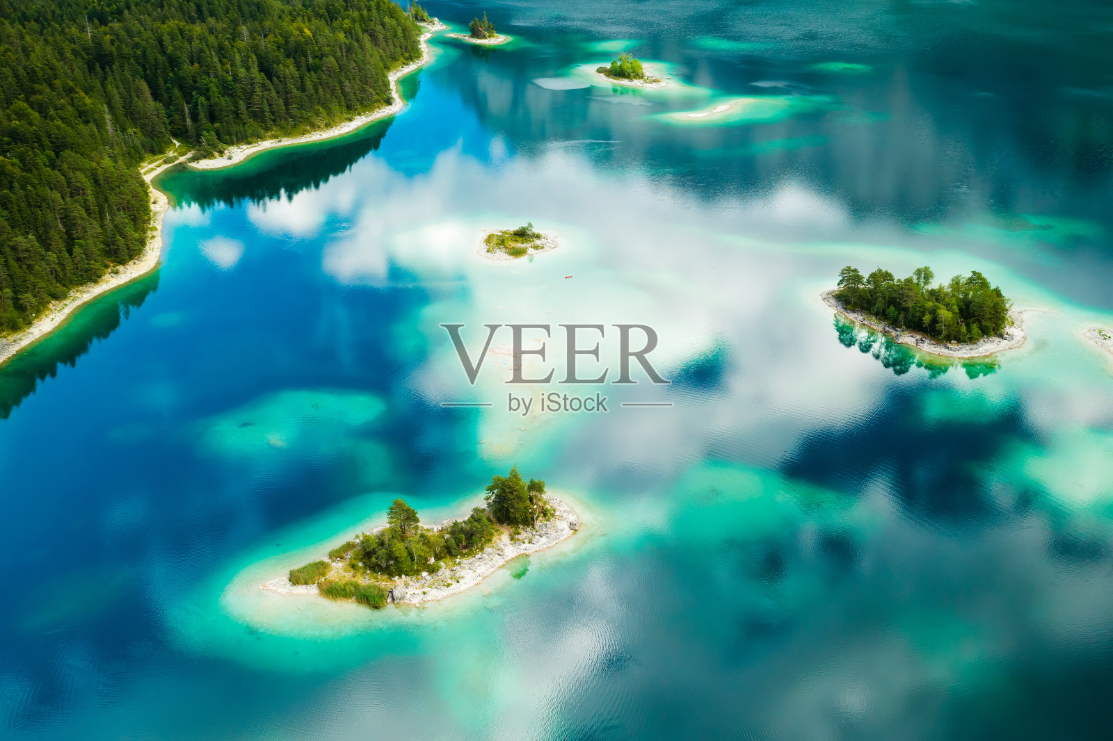 令人惊叹的岛屿，湖上有树，湖水绿松石色，云朵反射照片摄影图片