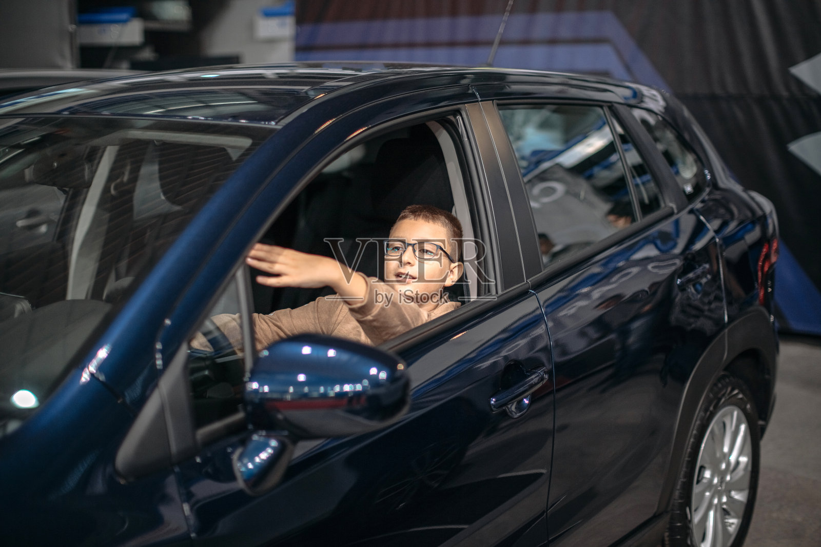 男孩坐在司机的座位上照片摄影图片