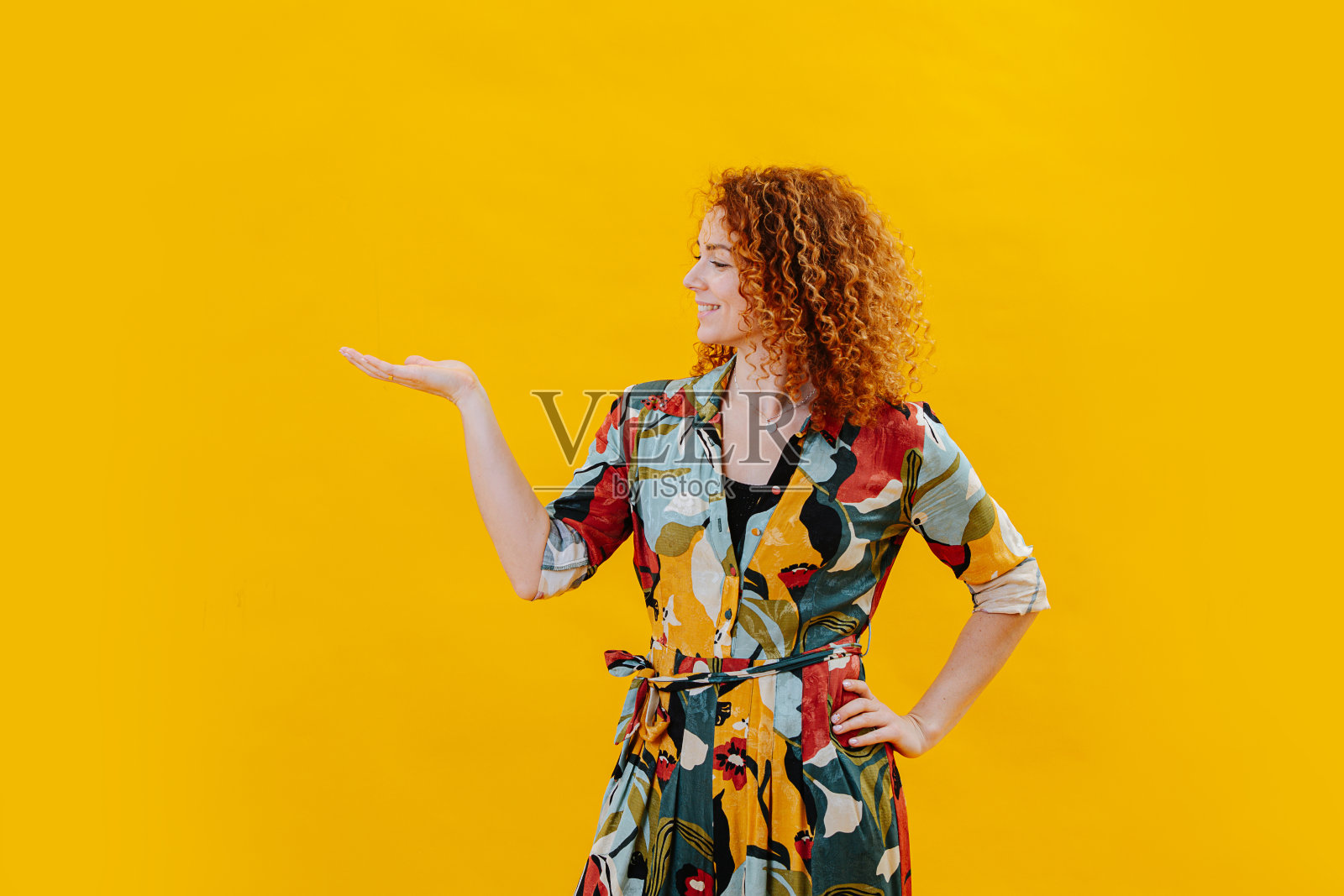 快乐自信的年轻女子摆好姿势，把她的手掌向上。照片摄影图片