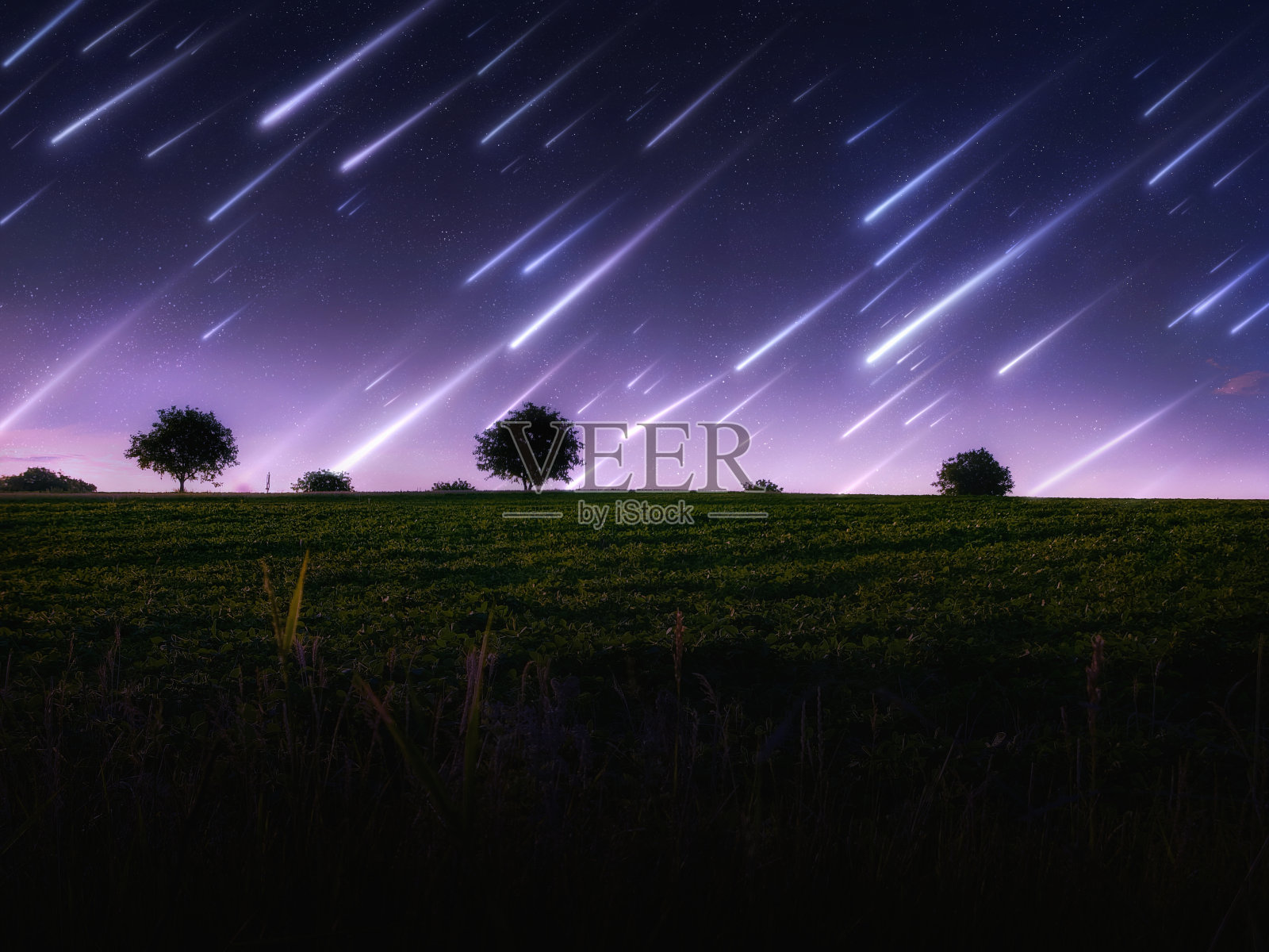 田野上日出时的流星雨。照片摄影图片