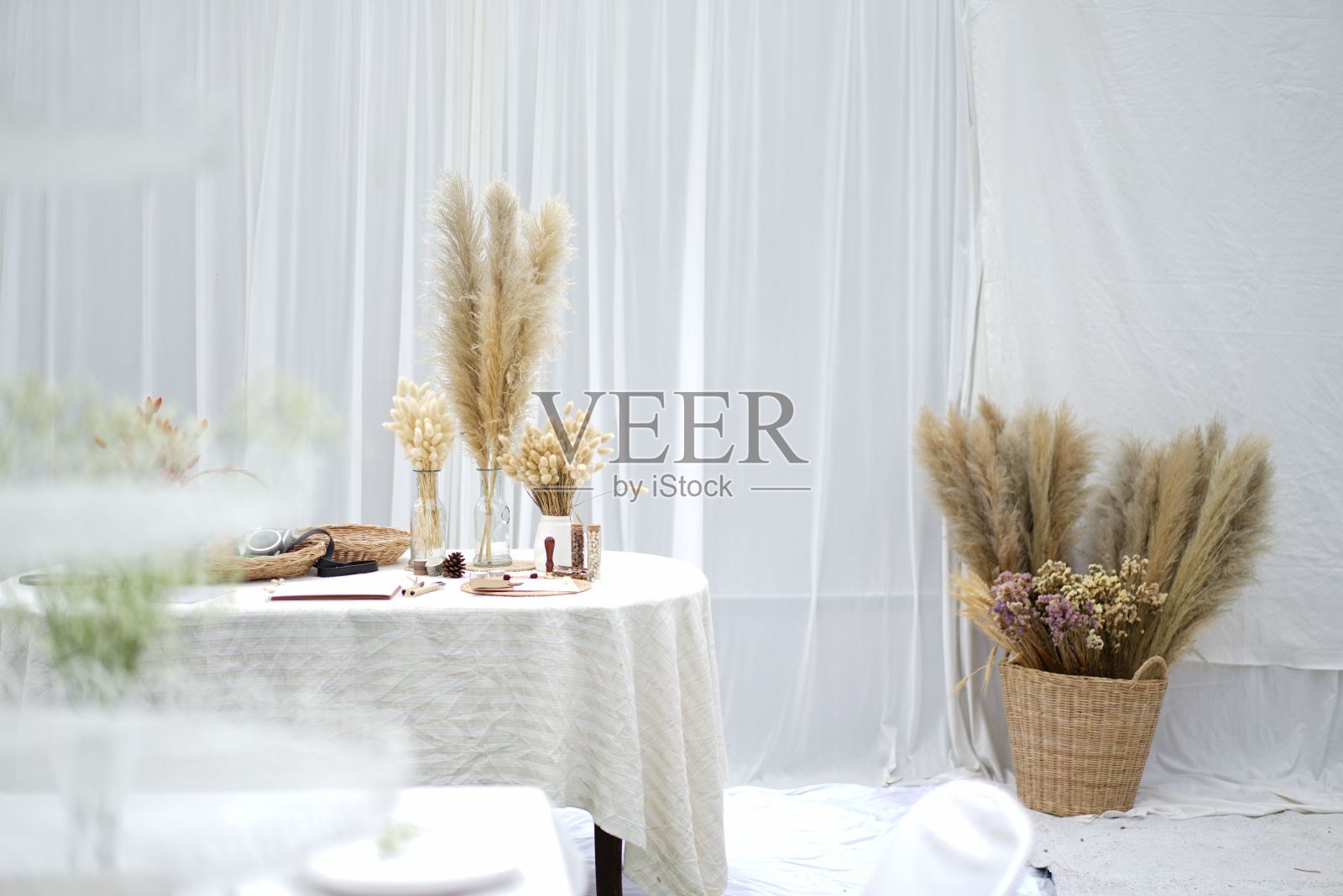 漂亮的装饰，干小麦和花篮子在地板上，花盆在桌子上照片摄影图片