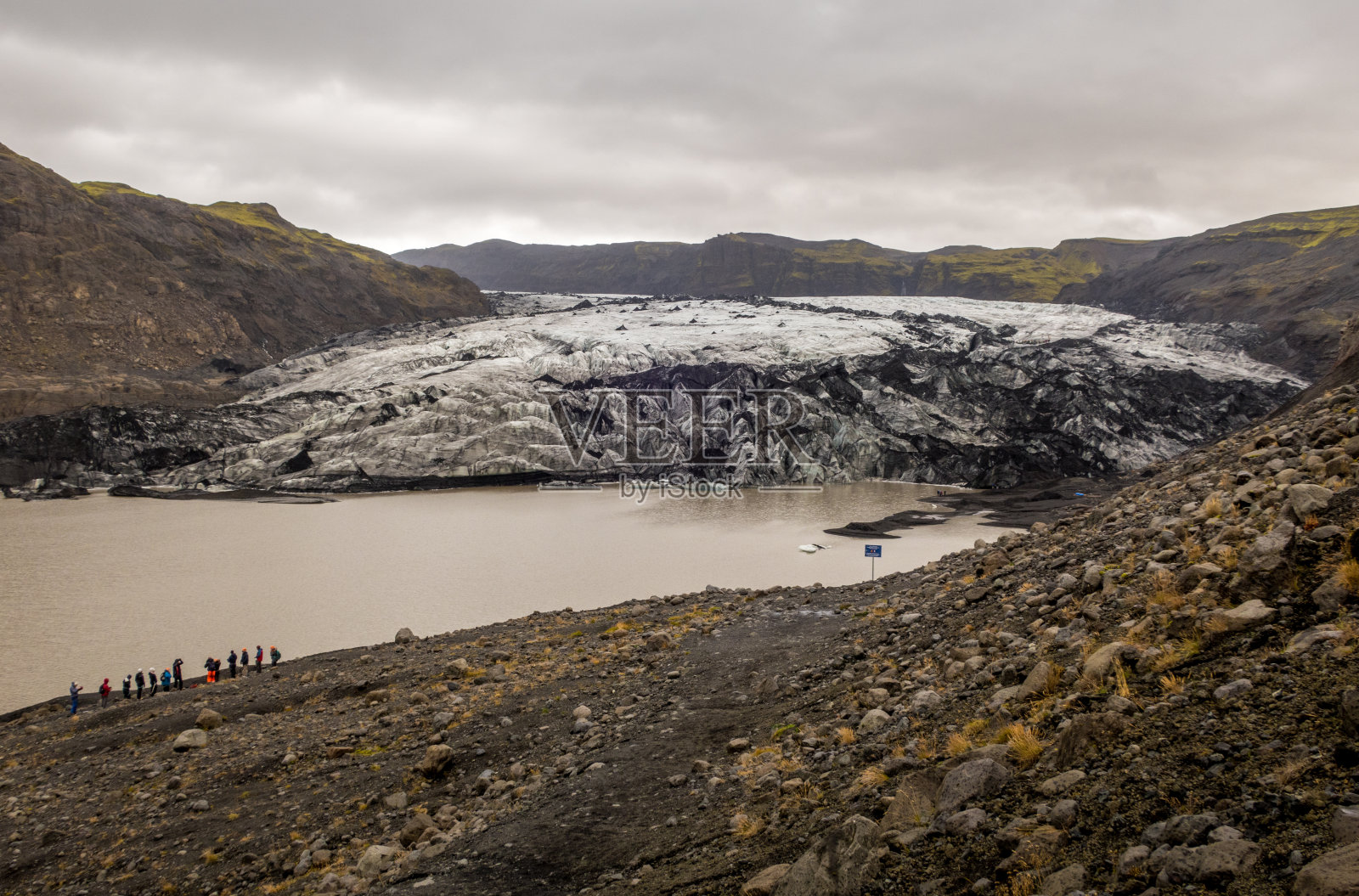在寒冷的天气里，一群旅行者在冰岛的Solheimajokull冰川上照片摄影图片