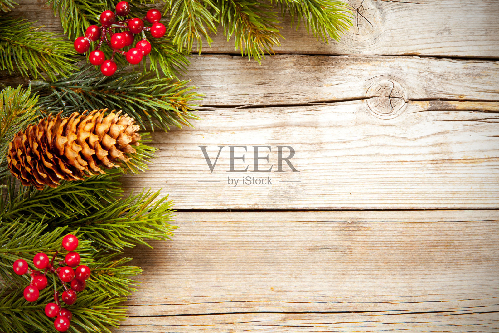 俯视图拍摄的圣诞树树枝与槲寄生和松果在木质表面照片摄影图片