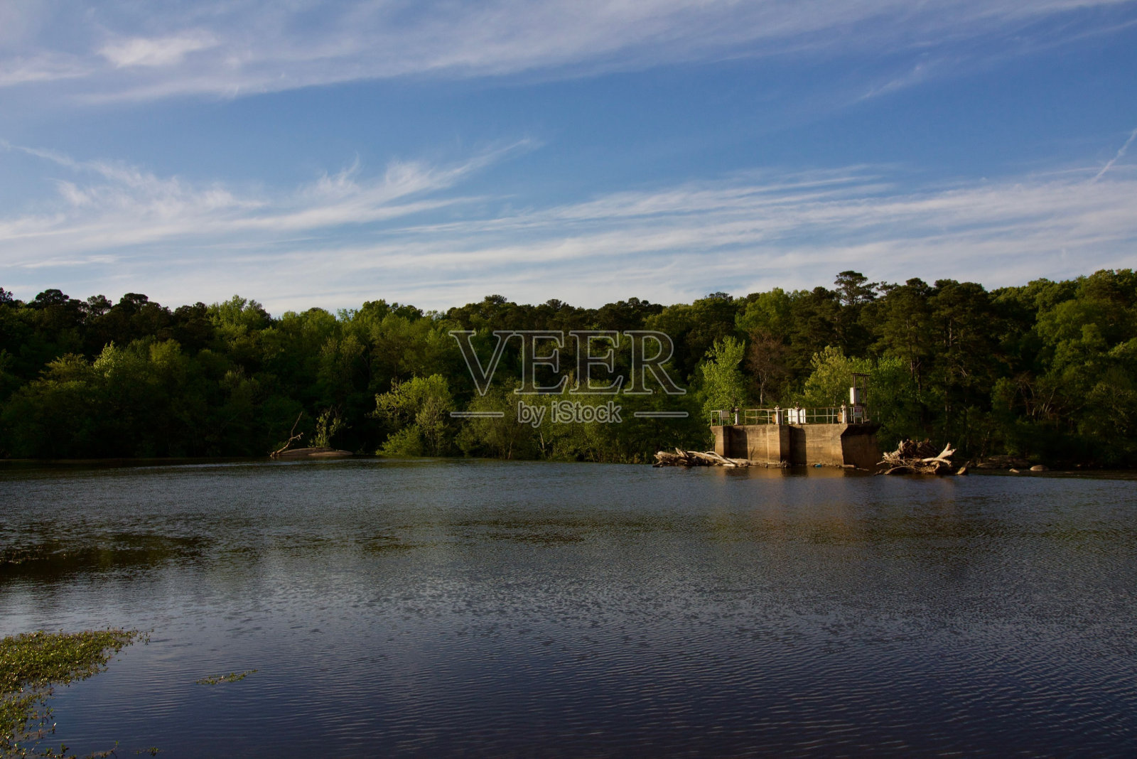 湖的另一边是一座古老建筑的废墟，周围是郁郁葱葱的森林照片摄影图片