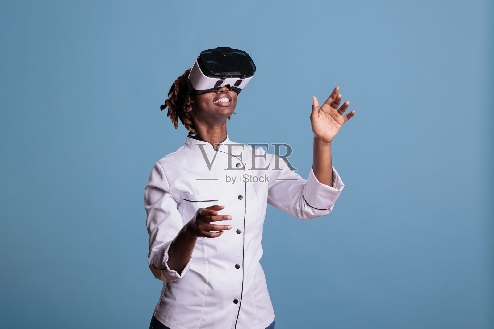 穿着制服的厨师在玩虚拟现实游戏照片摄影图片