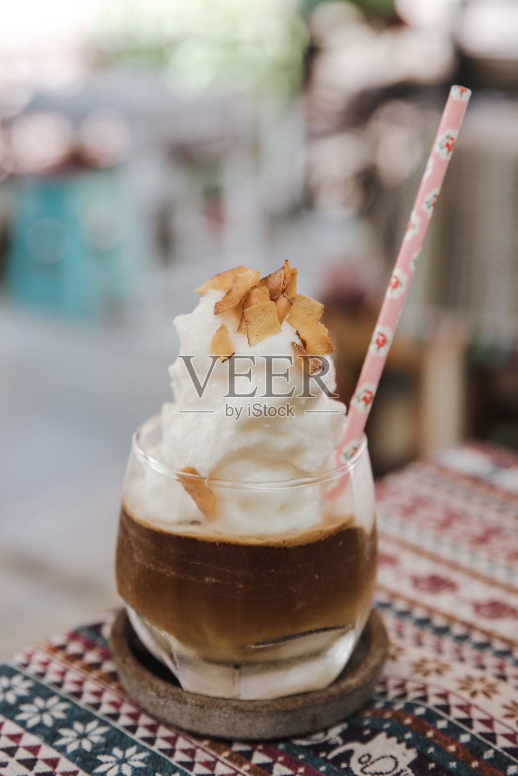 垂直拍摄的冰咖啡，上面有蒸汽泡沫和纸吸管照片摄影图片