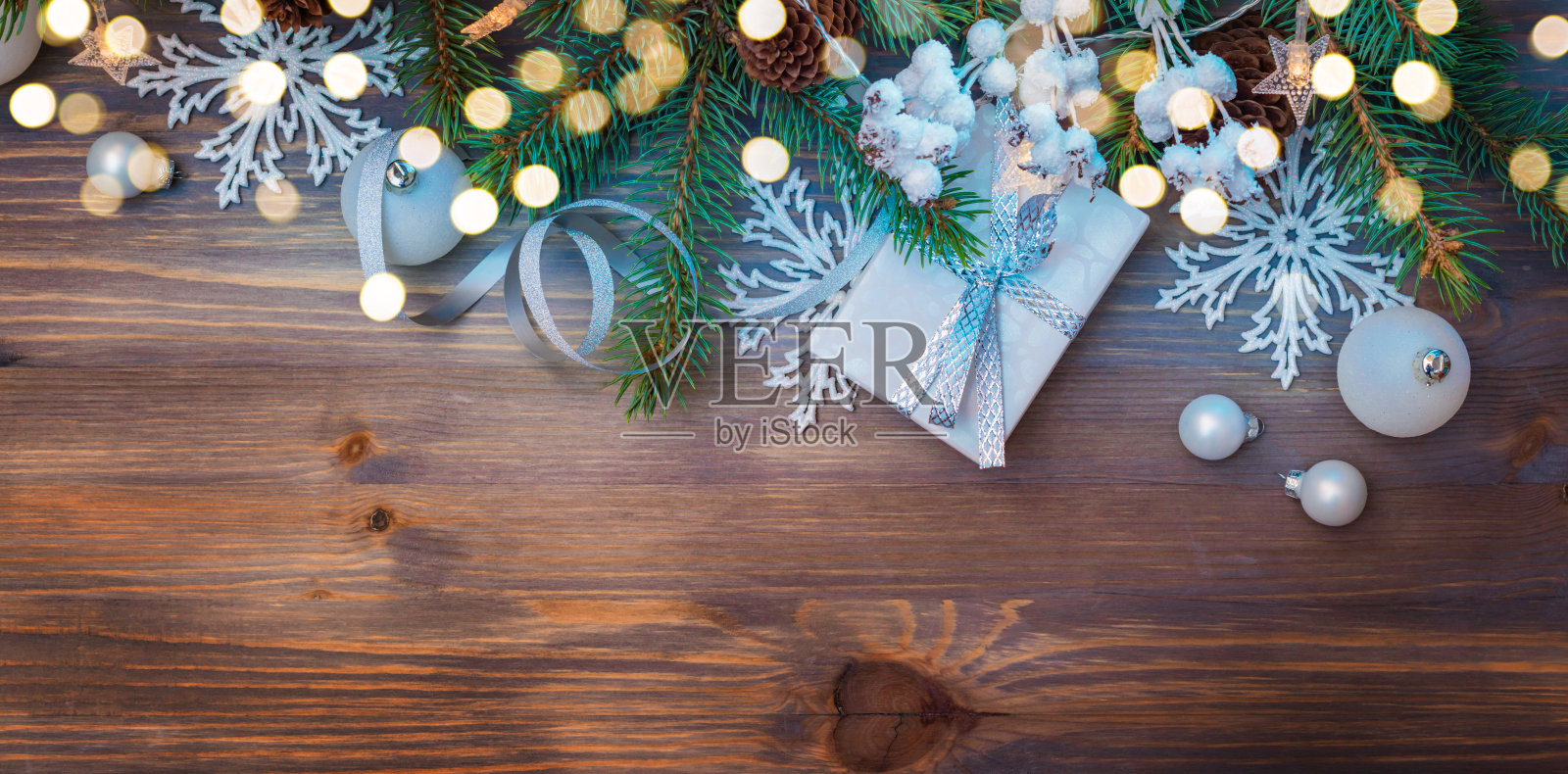 用杉木树枝和礼品盒平铺圣诞构图，花环放在木桌上。寒假背景与复制空间照片摄影图片